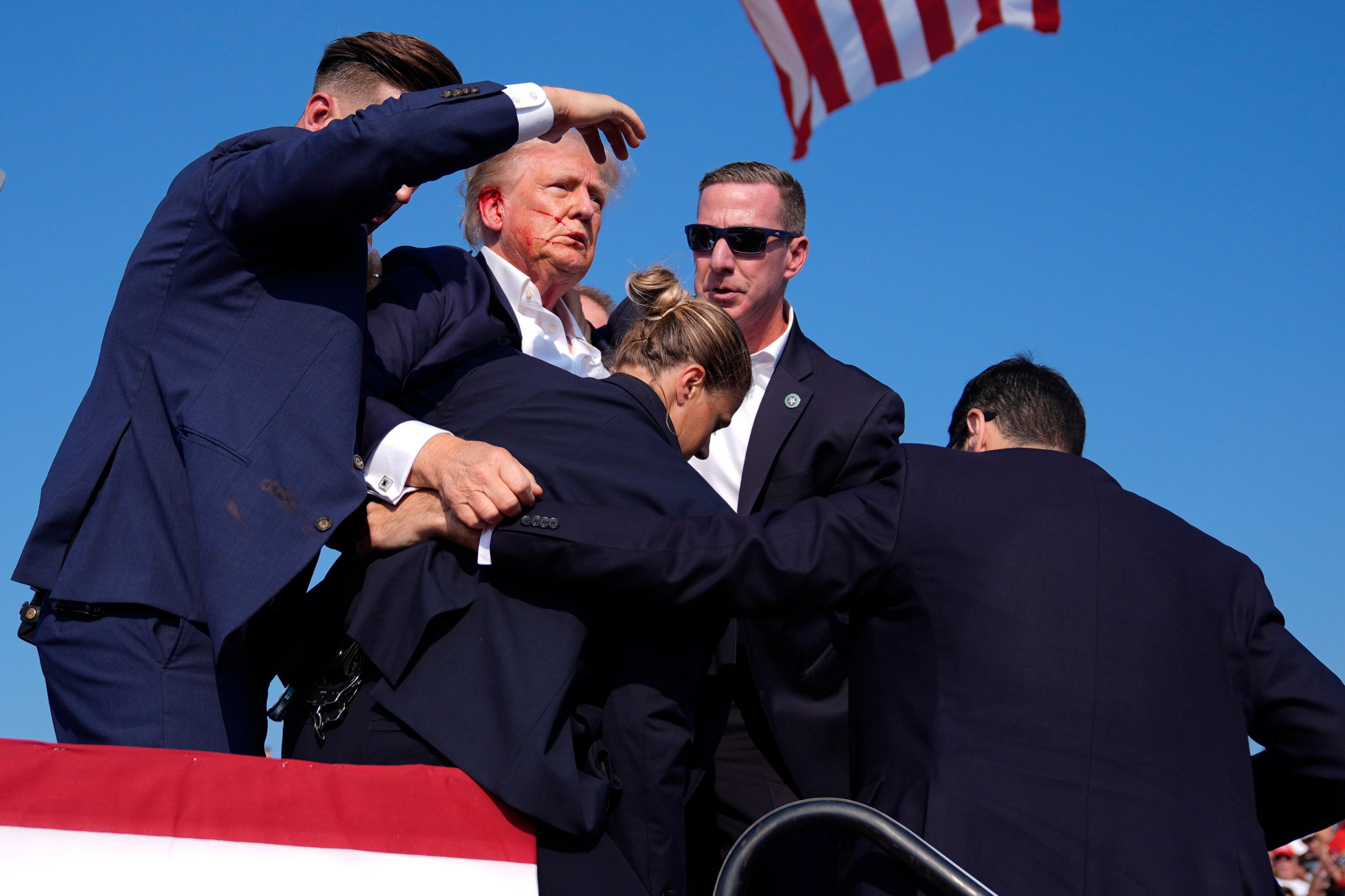 Secret Service agents swarm Donald Trump after he was struck by a bullet at the rally in Butler, Pennsylvania rally on July 13