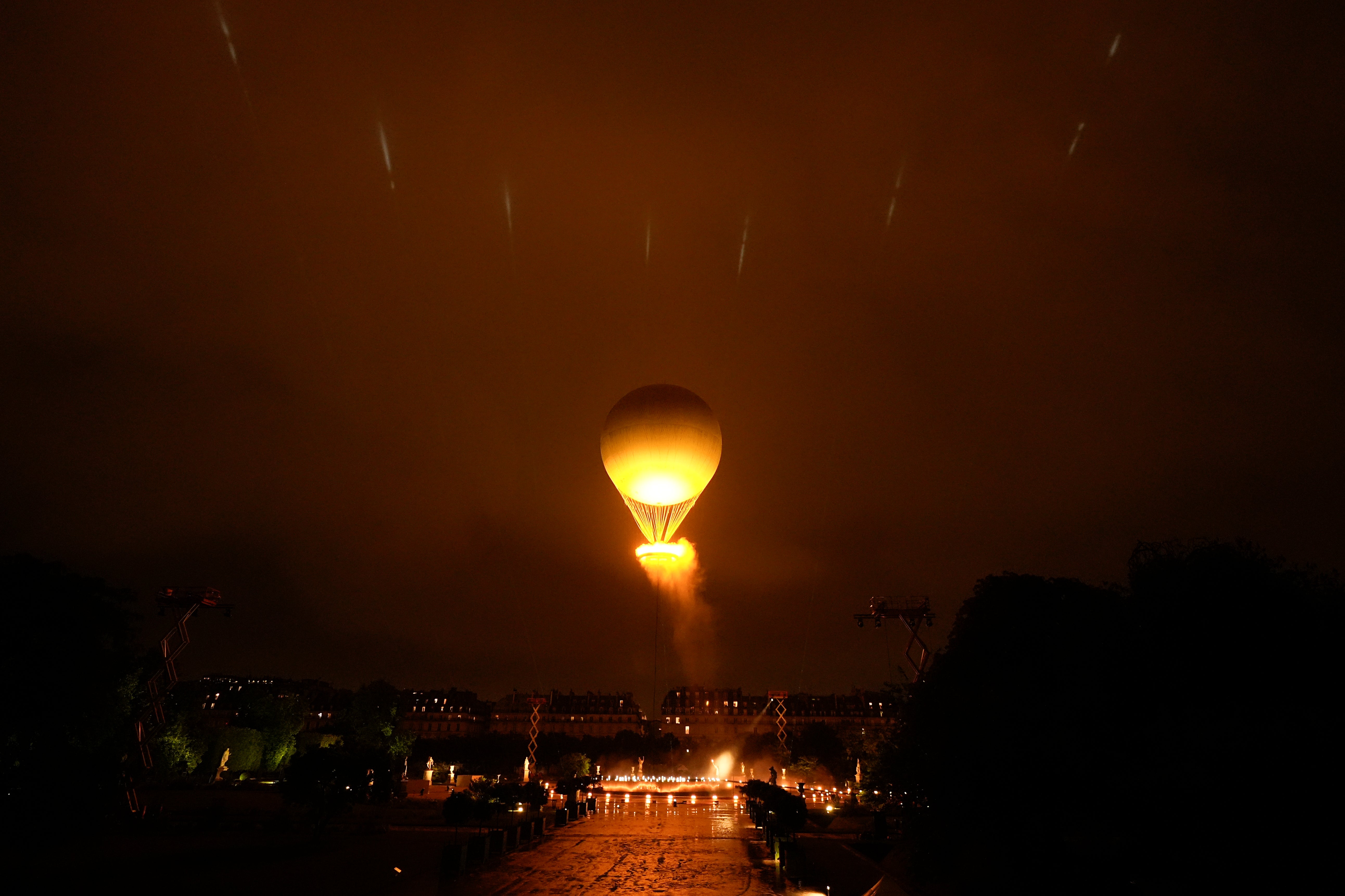 The Olympic flame rises above the city