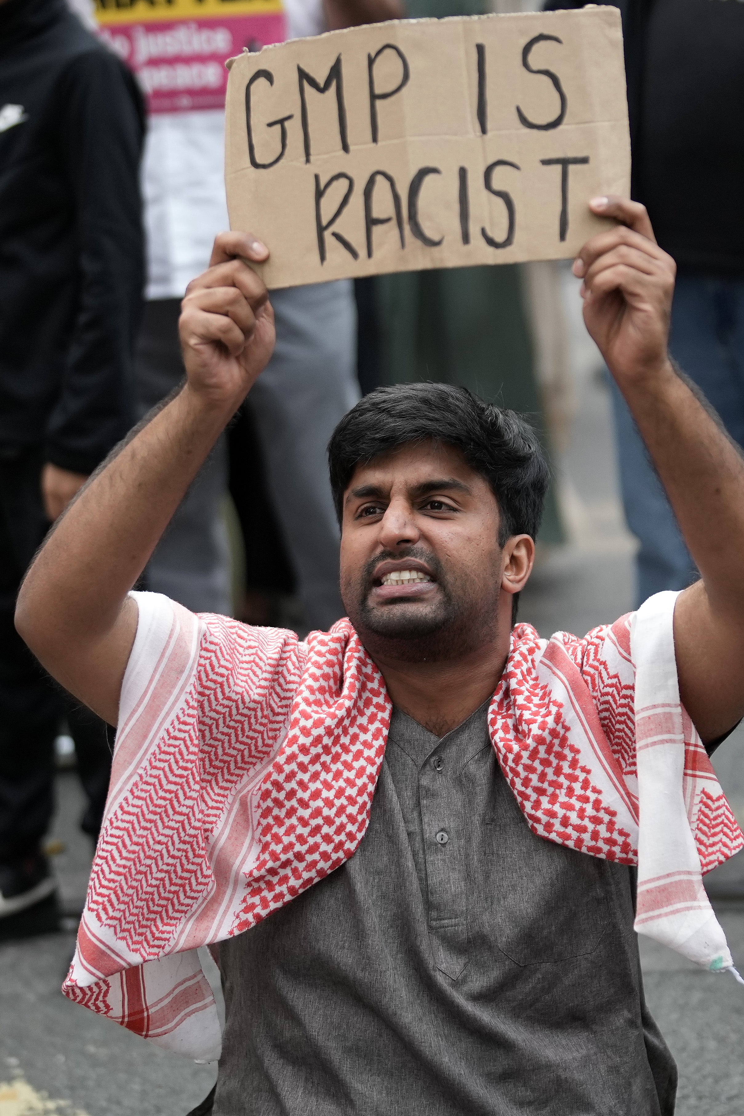 Protestors block the tram tracks, during a demonstration in the wake of a video showing a police officer kicking a man as he was being detained at Manchester Airport yesterday, on 25 July 2024 in Manchester, England