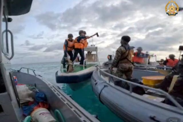 <p>File image: - In this image provided by Armed Forces of the Philippines, a Chinese Coast Guard holds an axe as they approach Philippine troops on a resupply mission in the Second Thomas Shoal at the disputed South China Sea in June</p>