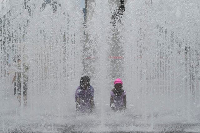 <p>Children cool themselves off in a public fountain in Seoul, South Korea</p>