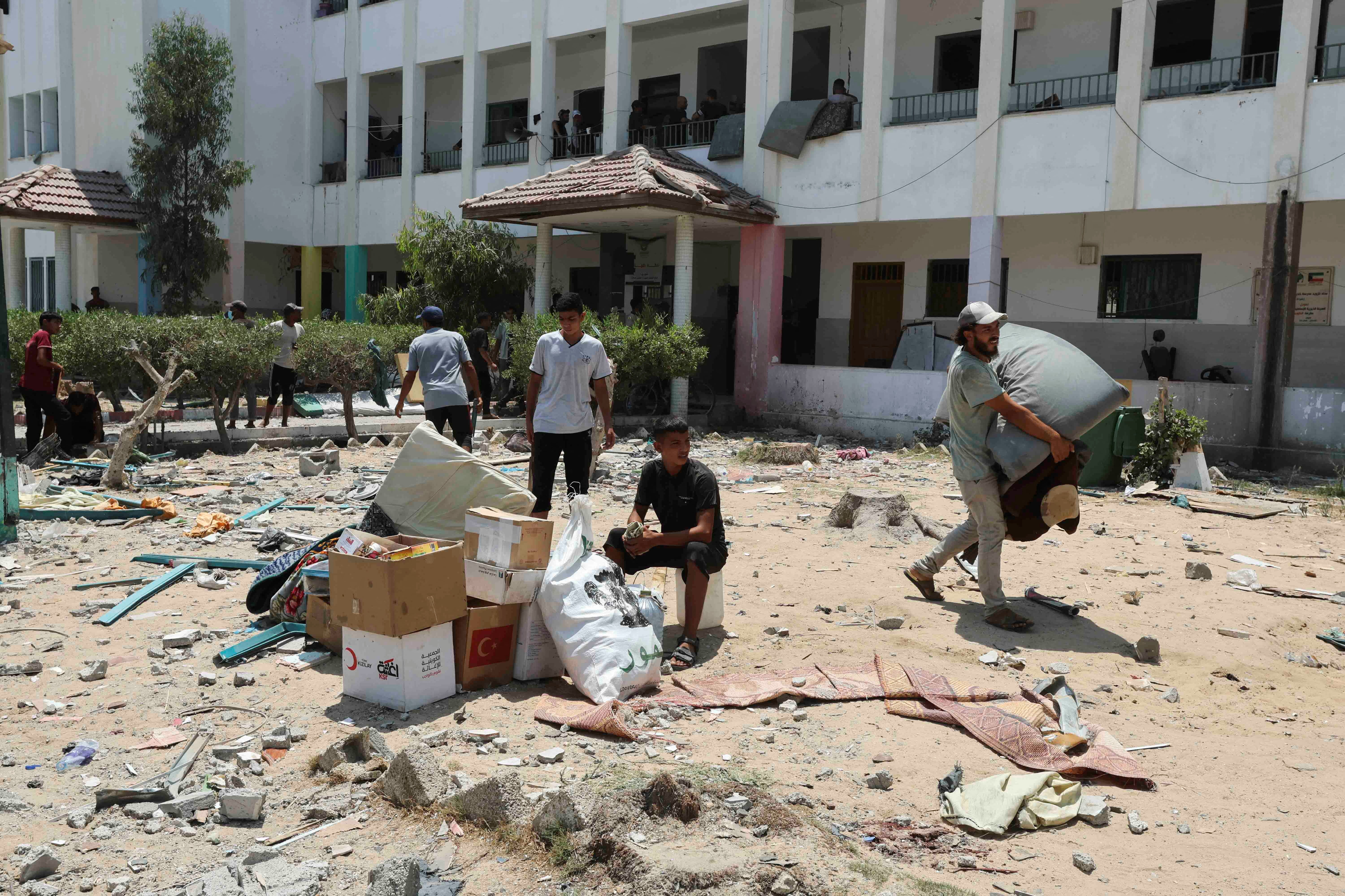 Palestinians seen leaving the school after an airstrike killed at least 30 people