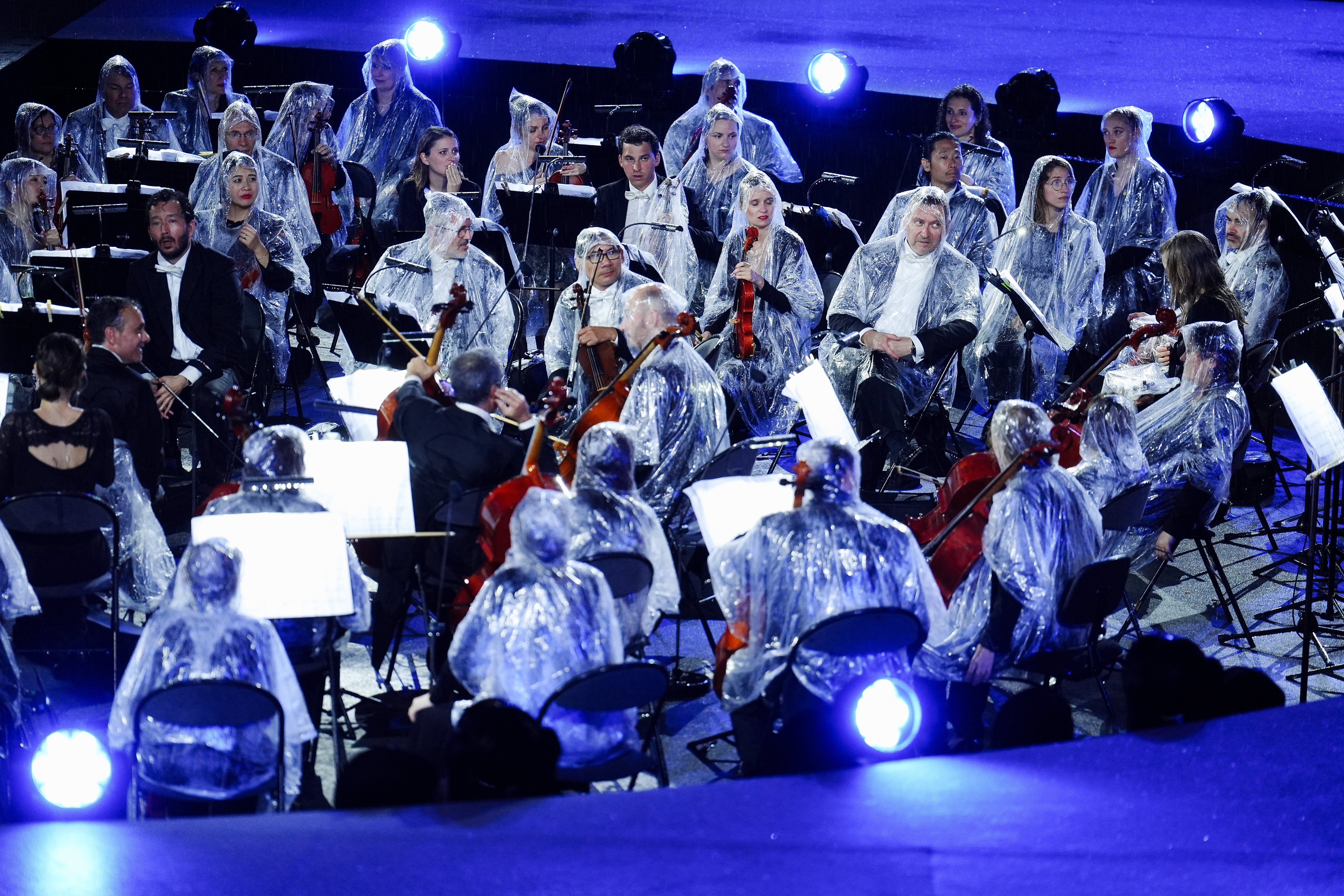 Musicians from the French National Orchestra shelter from the rain during the opening ceremony of the Paris 2024 Olympic Games (Mike Egerton/PA).