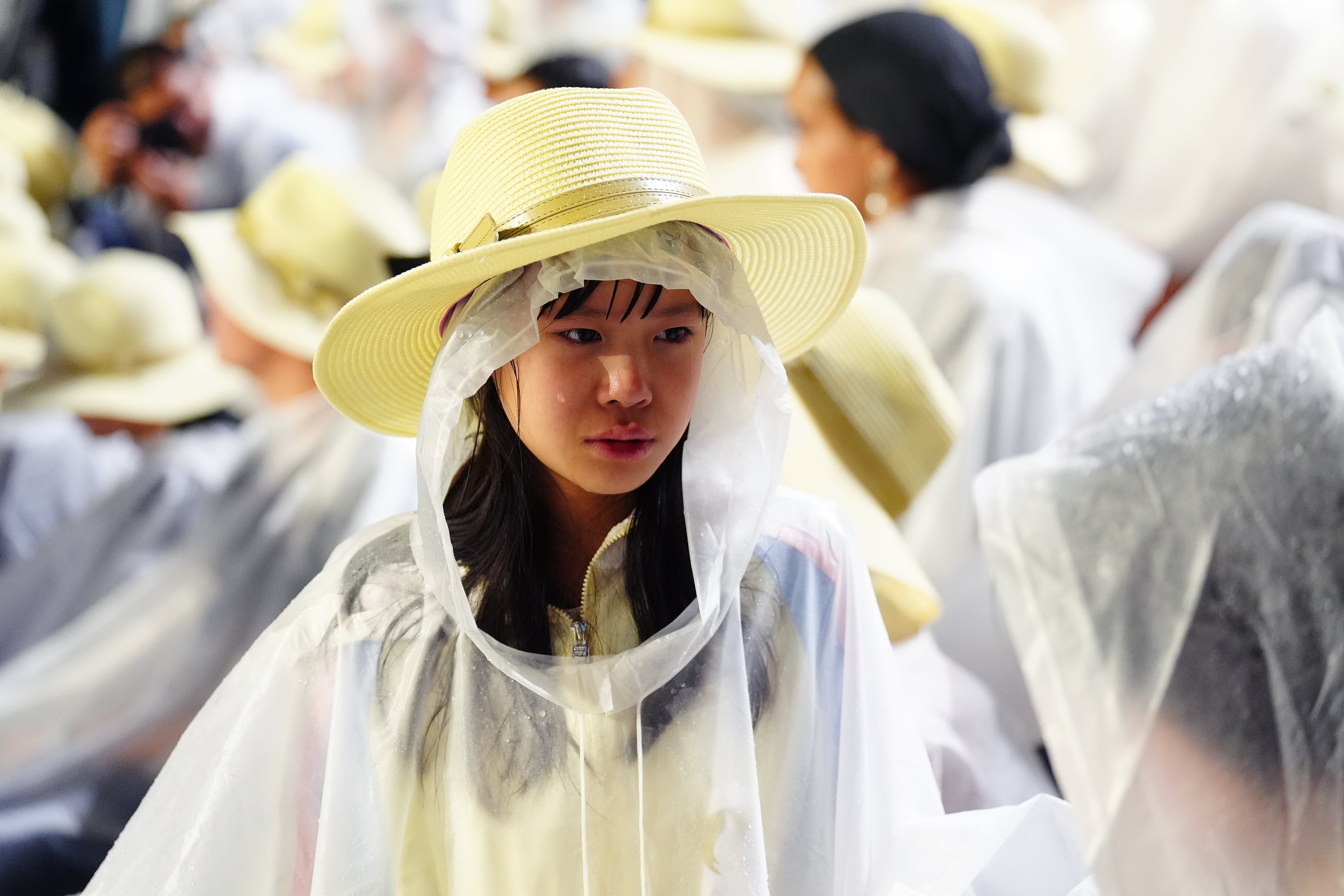 A spectator shelters from the rain at the Trocadero during the opening ceremony of the Paris 2024 Olympic Games (Mike Egerton/PA).