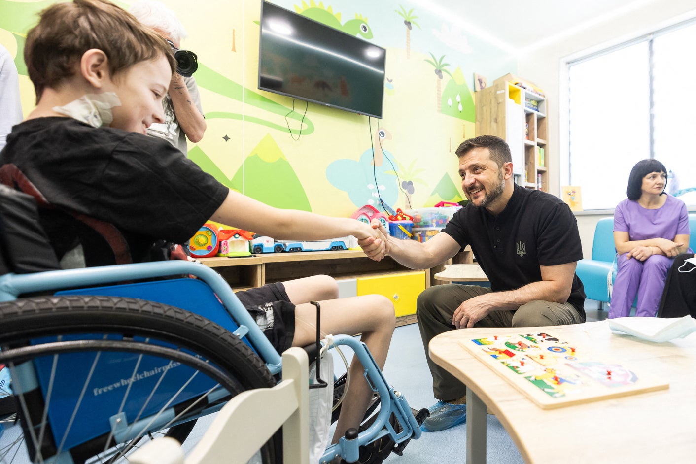 Ukraine's President Volodymyr Zelensky shakes hands with a child during his visit to the Ohmatdyt Children's Hospital in Kyiv