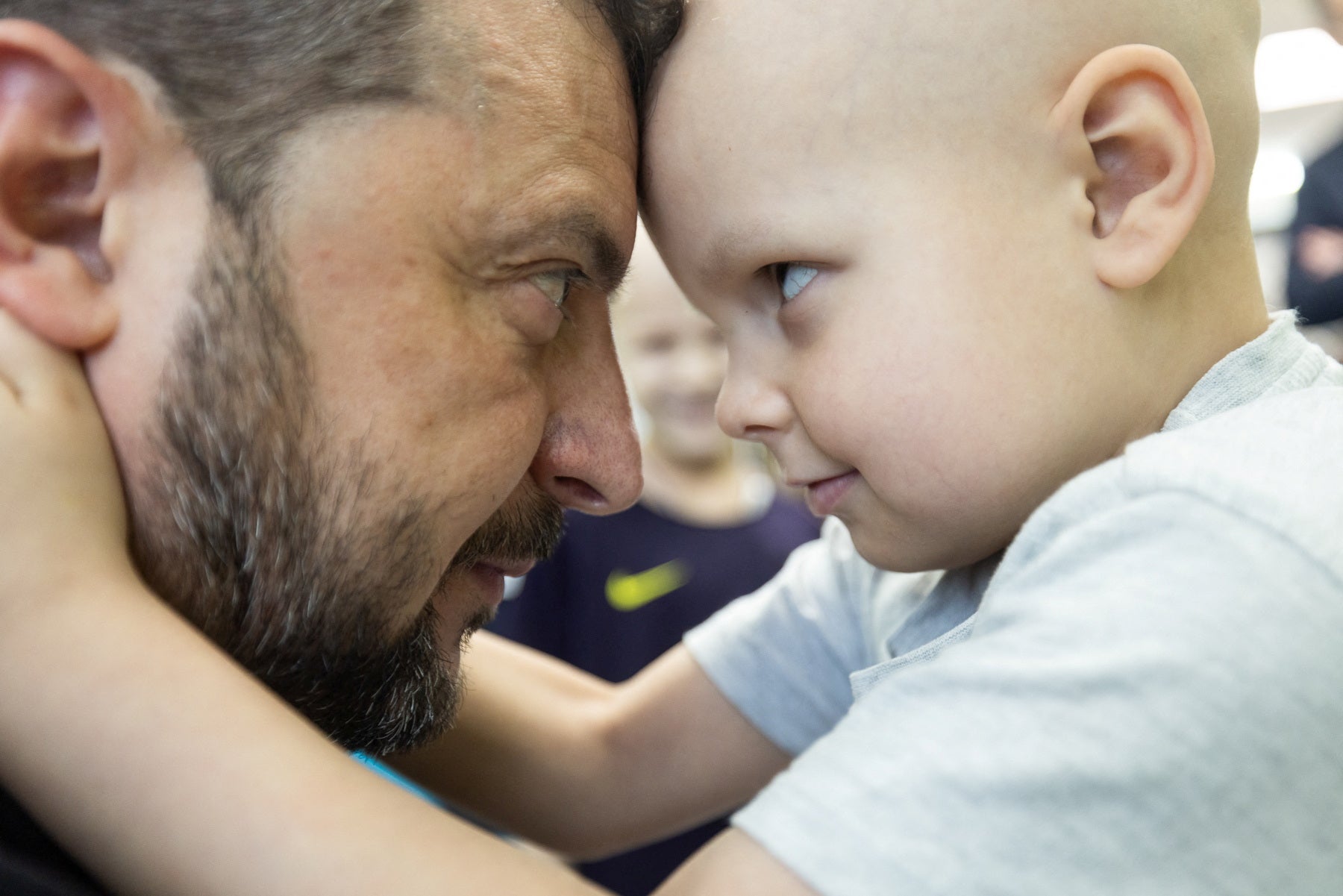 A close-up image shows Ukrainian President Volodymyr Zelenskyy touching heads with patients at Okhmatdyt Pediatric Hospital.