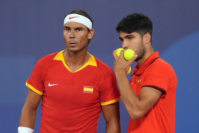 Rafael Nadal and Carlos Alcaraz talk during their first-round doubles match (Martin Rickett/PA)