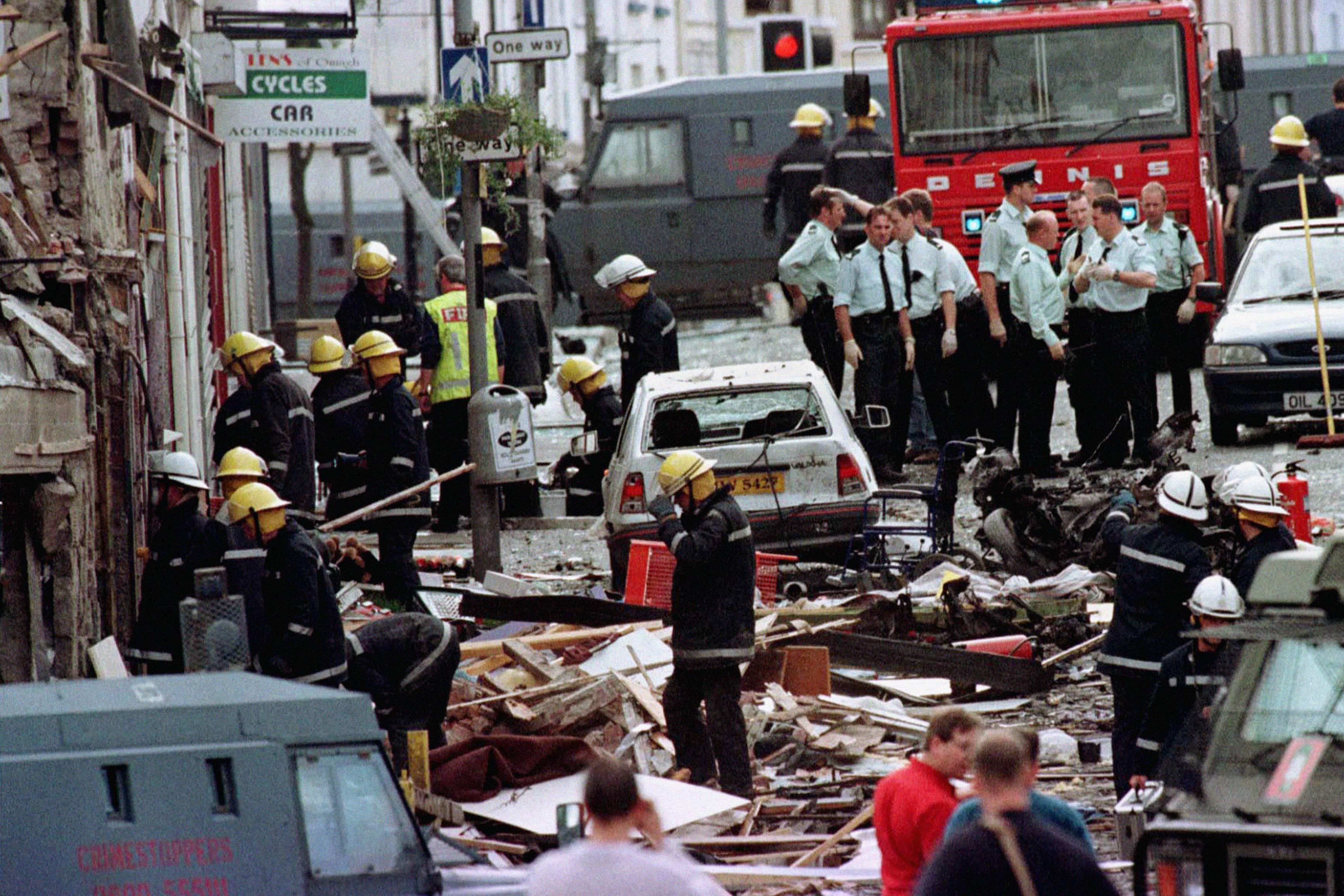 Police officers and firefighters inspect the damage caused by the explosion in Market Street, Omagh in 1998 (Paul McErlane/PA)