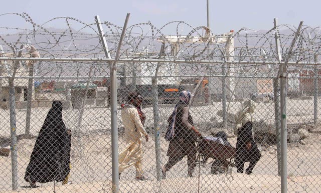 <p>File. People walk near Pakistan’s border with Afghanistan</p>