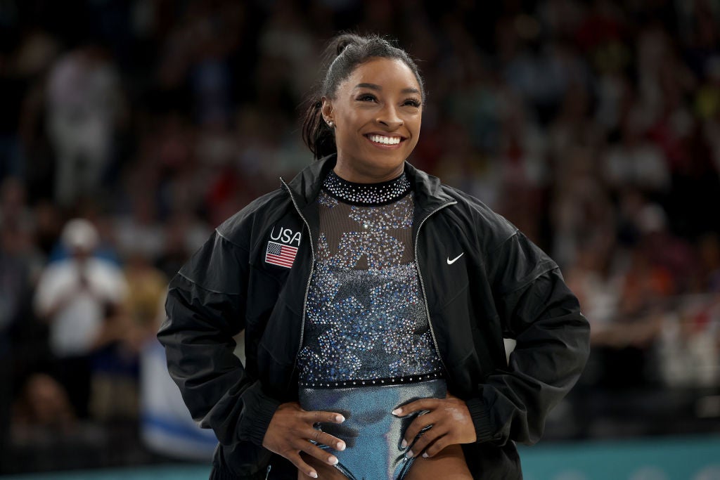 Simone Biles smiles as she arrives for the qualification session