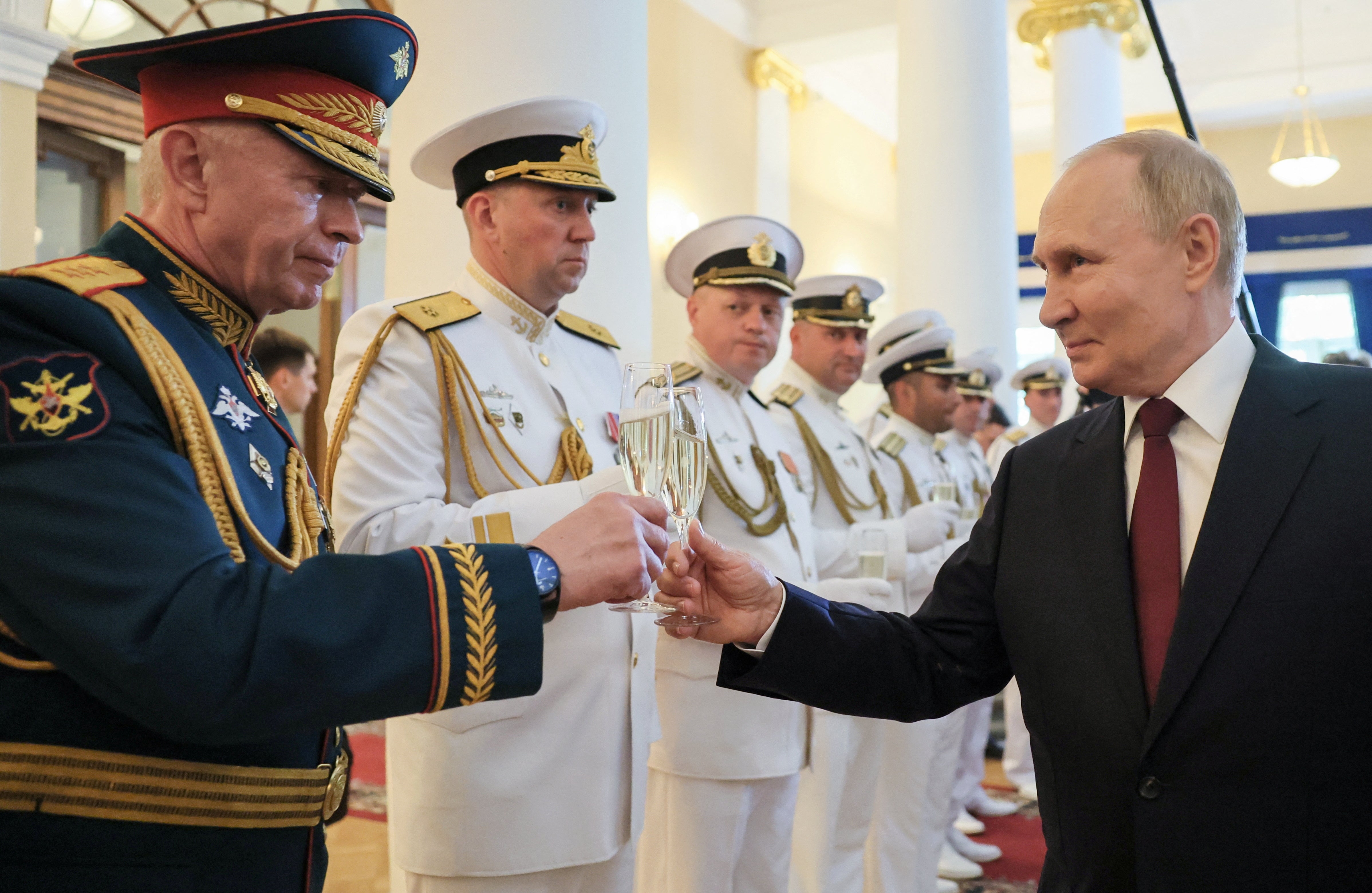 Russia's President Vladimir Putin toasts with sailors and heads of foreign delegations involved in celebrations of Russia's Navy Day