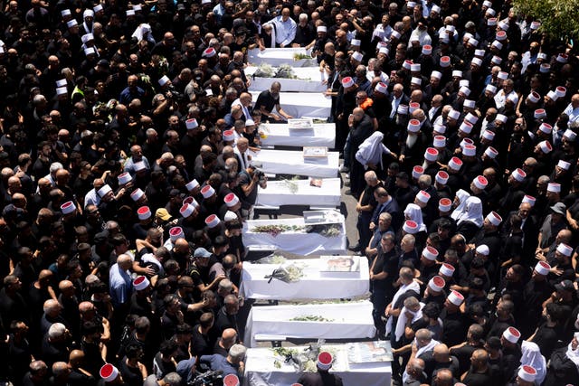 <p>Mourners attend a funeral held for 10 of the victims of yesterday's rocket attack  </p>