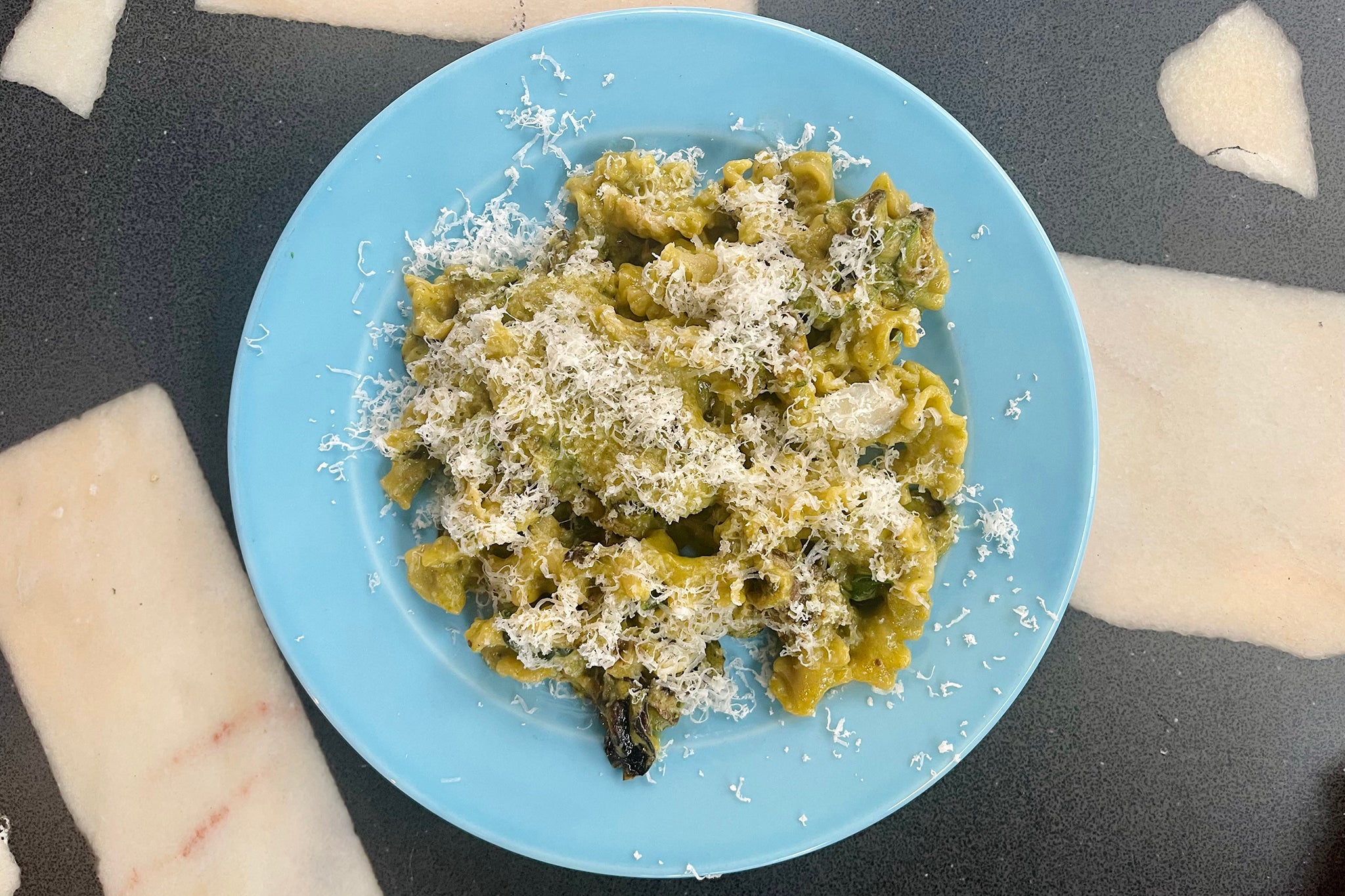 A vibrant, herb-infused summer dish topped with a generous grating of Provolone