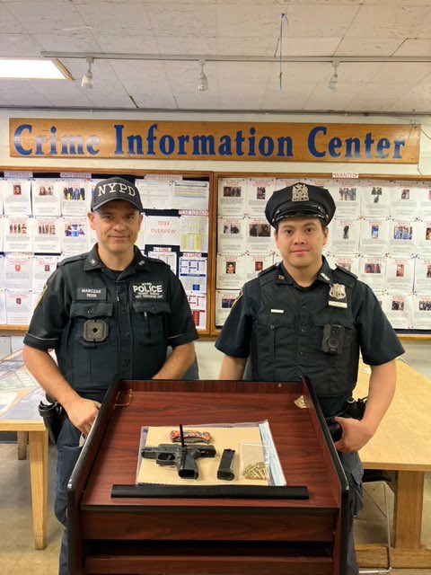 Officers pose with the gun that they seized from the sleeping man on the subway they arrested on Sunday