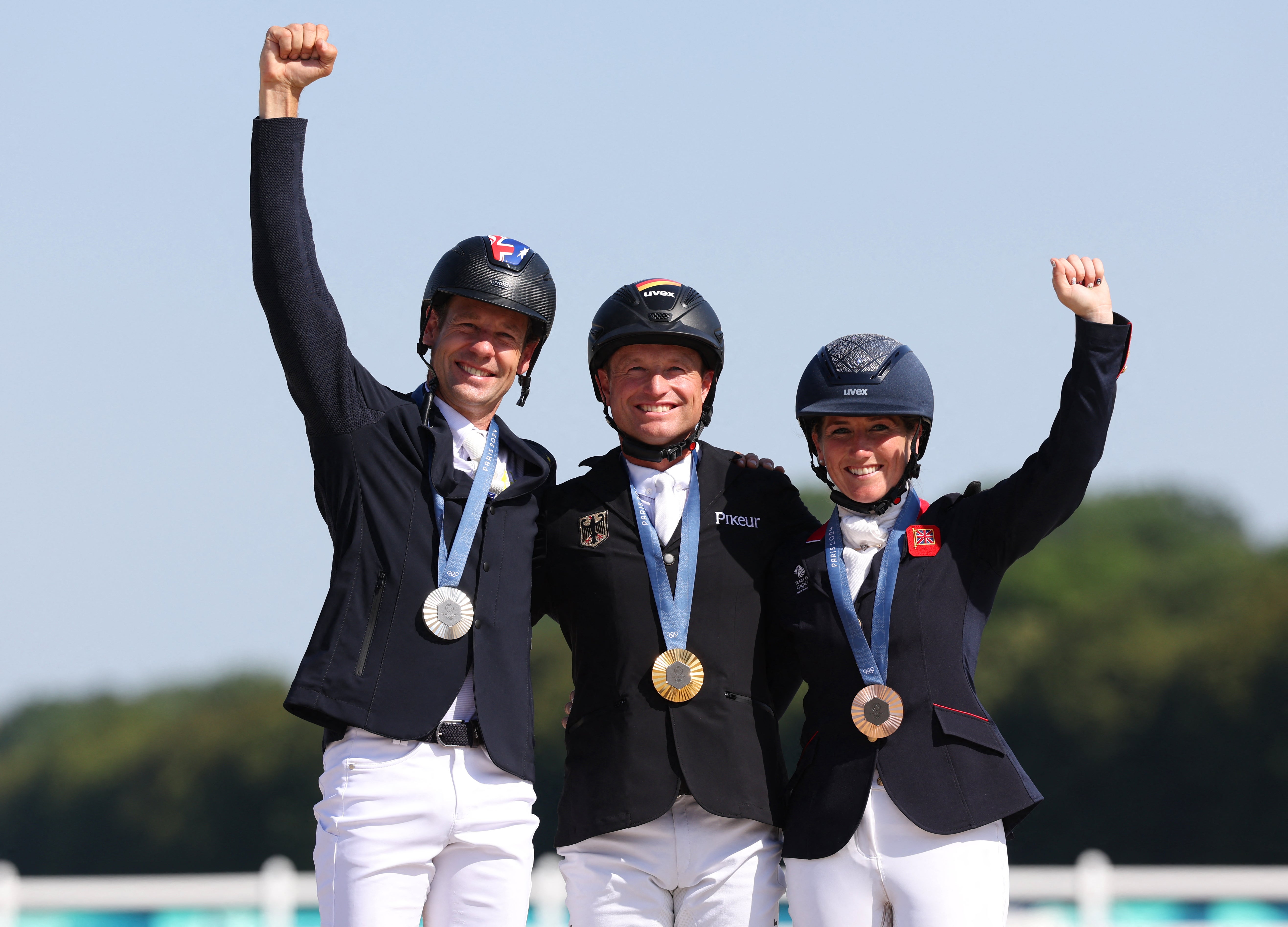 Australia's silver medalist Christopher Burton, Germany's gold medalist Michael Jung and Britain's bronze medalist Laura Collett celebrate