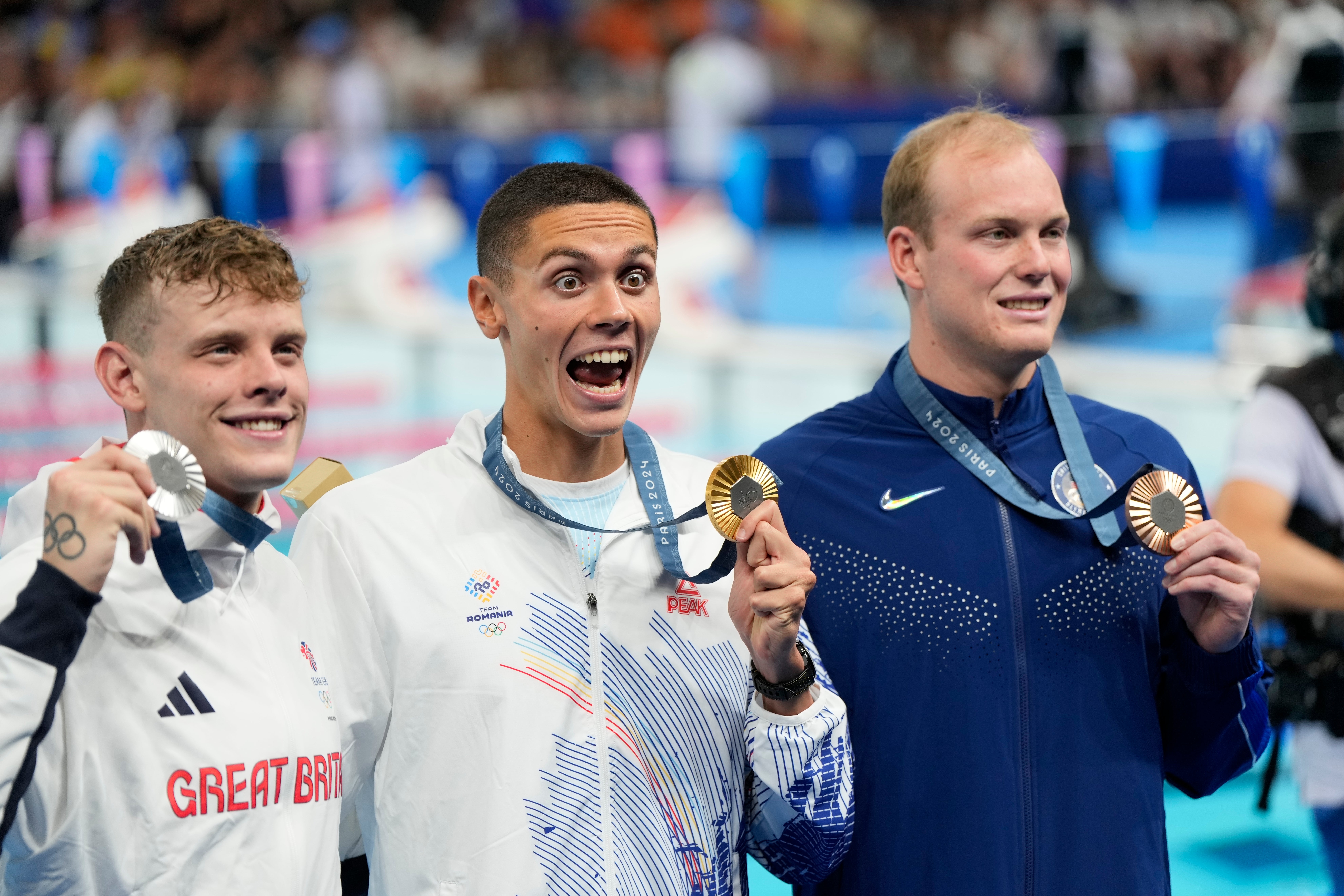 Gold medalist David Popovici, of Romania, centre, poses with silver medalist Matthew Richards, of Britain, left, and bronze medalist Luke Hobson, of the United States