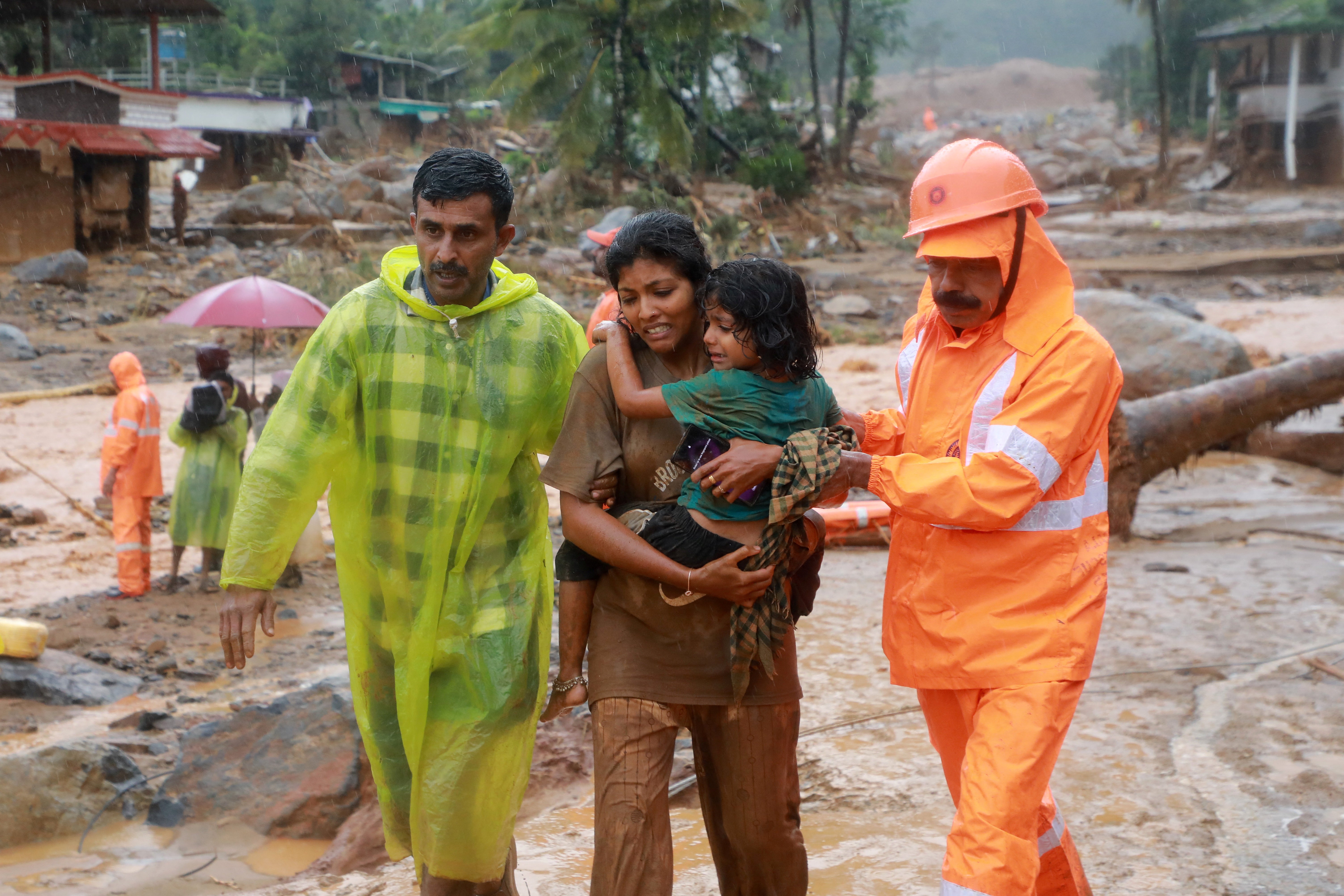 Rescuers help residents to move to a safer place, at a landslide site after multiple landslides in the hills, in Wayanad, in the southern state of Kerala, India