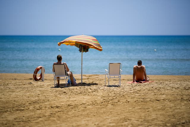 <p>Tourists sit on the beach of the sea town of Porto Empedocle, in southern Sicily, Italy, Thursday, July 18, 2024</p>