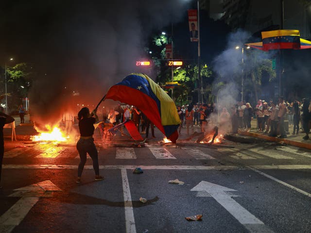 <p>A protester waves the Venezuelan flag during a demonstration against the election result </p>