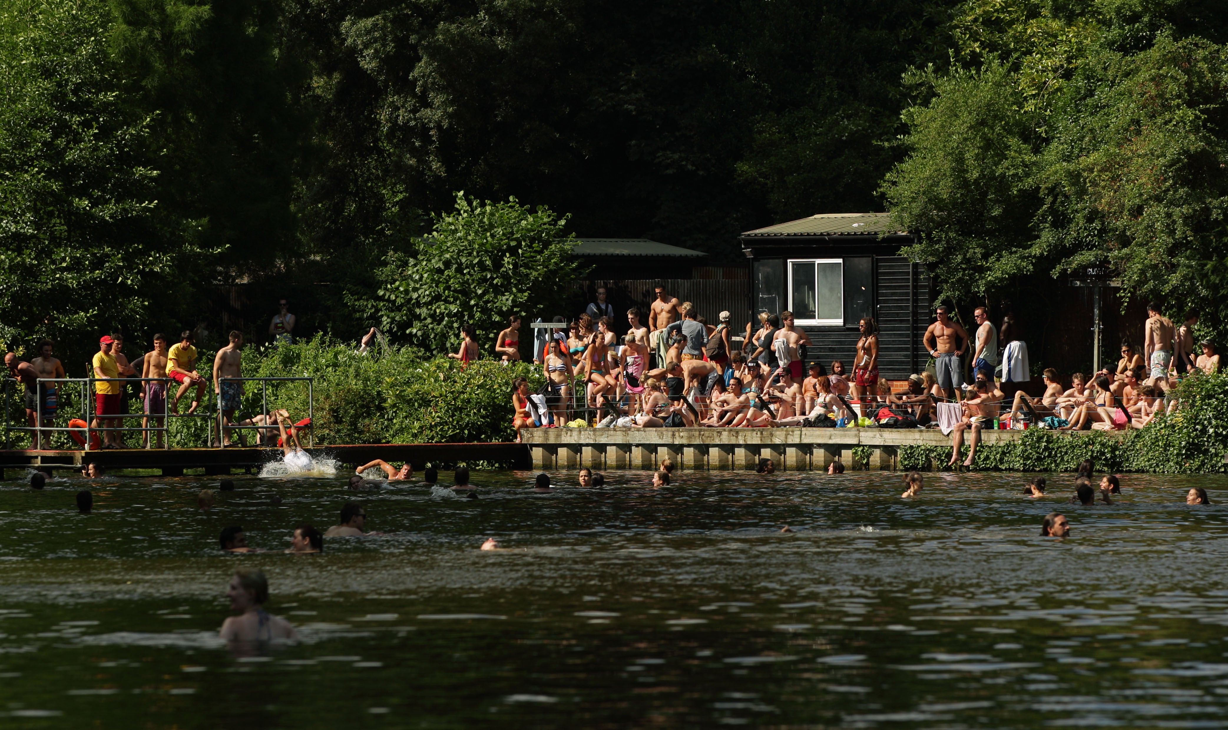 People flock to the ponds on Hampstead Heath in London to cool off in the heat (Yui Mok/PA)