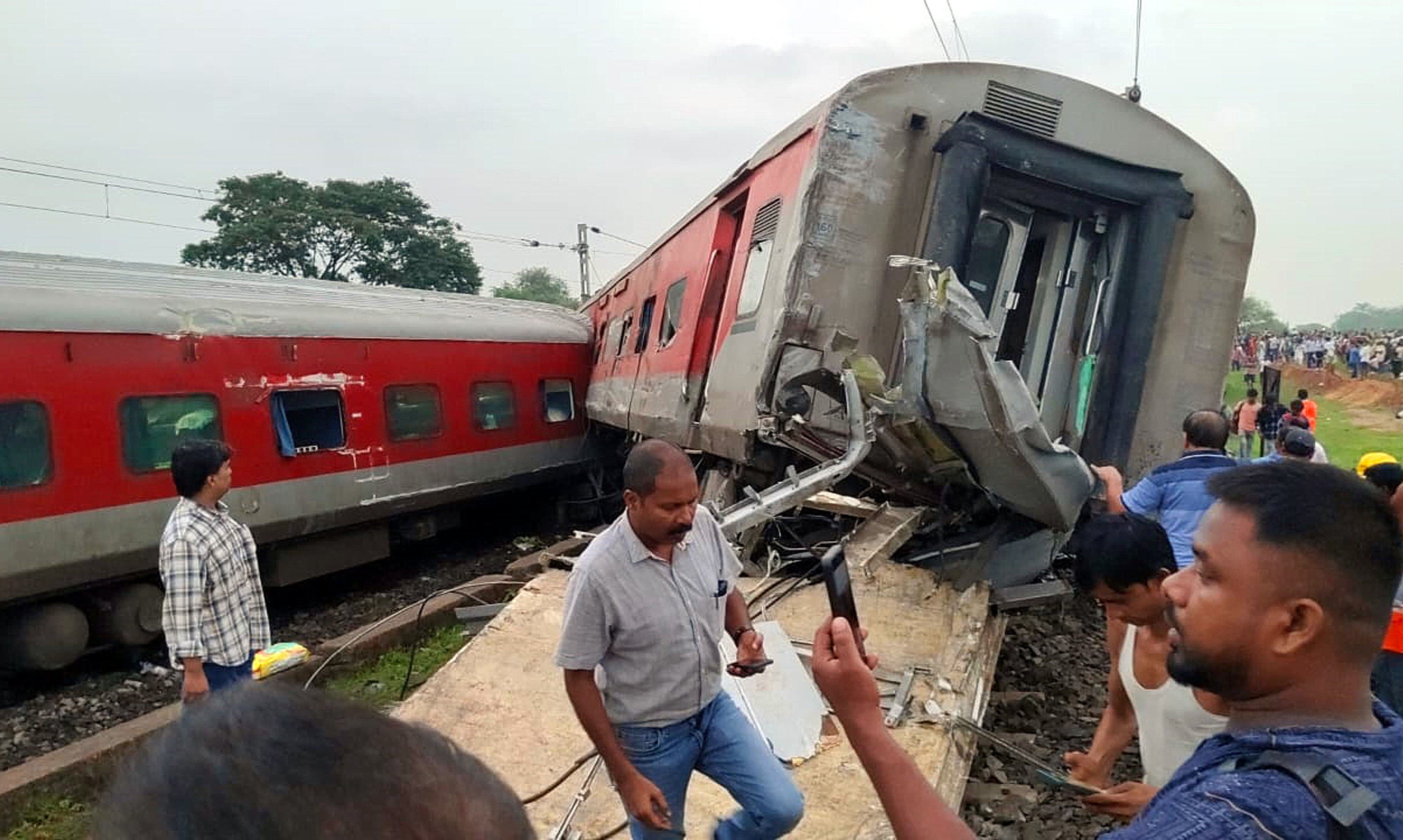 People gather at the site of train derailment near Badabamboo in Jharkhand, India, on 30 July 2024