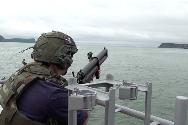 <p>A Russian service member fires from aboard a warship during naval exercises at an undisclosed location</p>