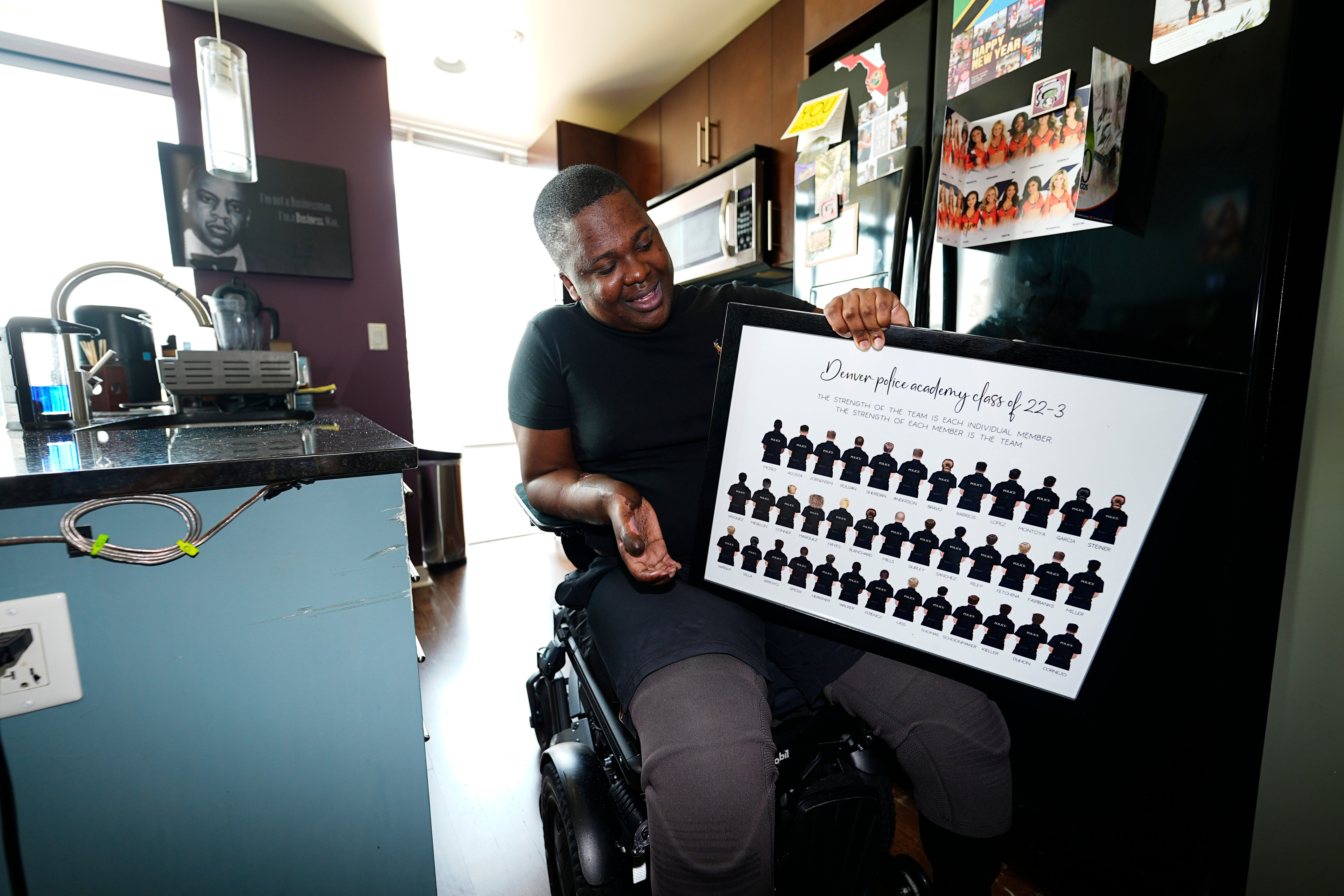 Victor Moses holds a framed photograph of the class that he was part of at the Denver Police Department academy