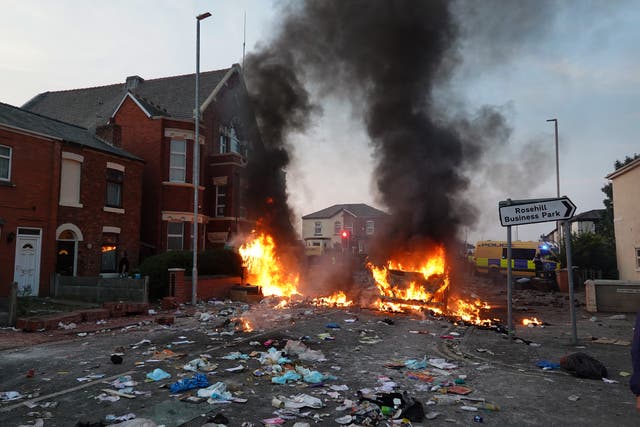 <p>Protesters set fire to rubbish on the streets in Southport on Tuesday </p>