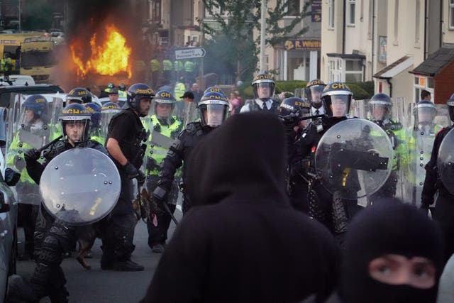 <p>Riot police hold back protesters after disorder broke out in Southport </p>