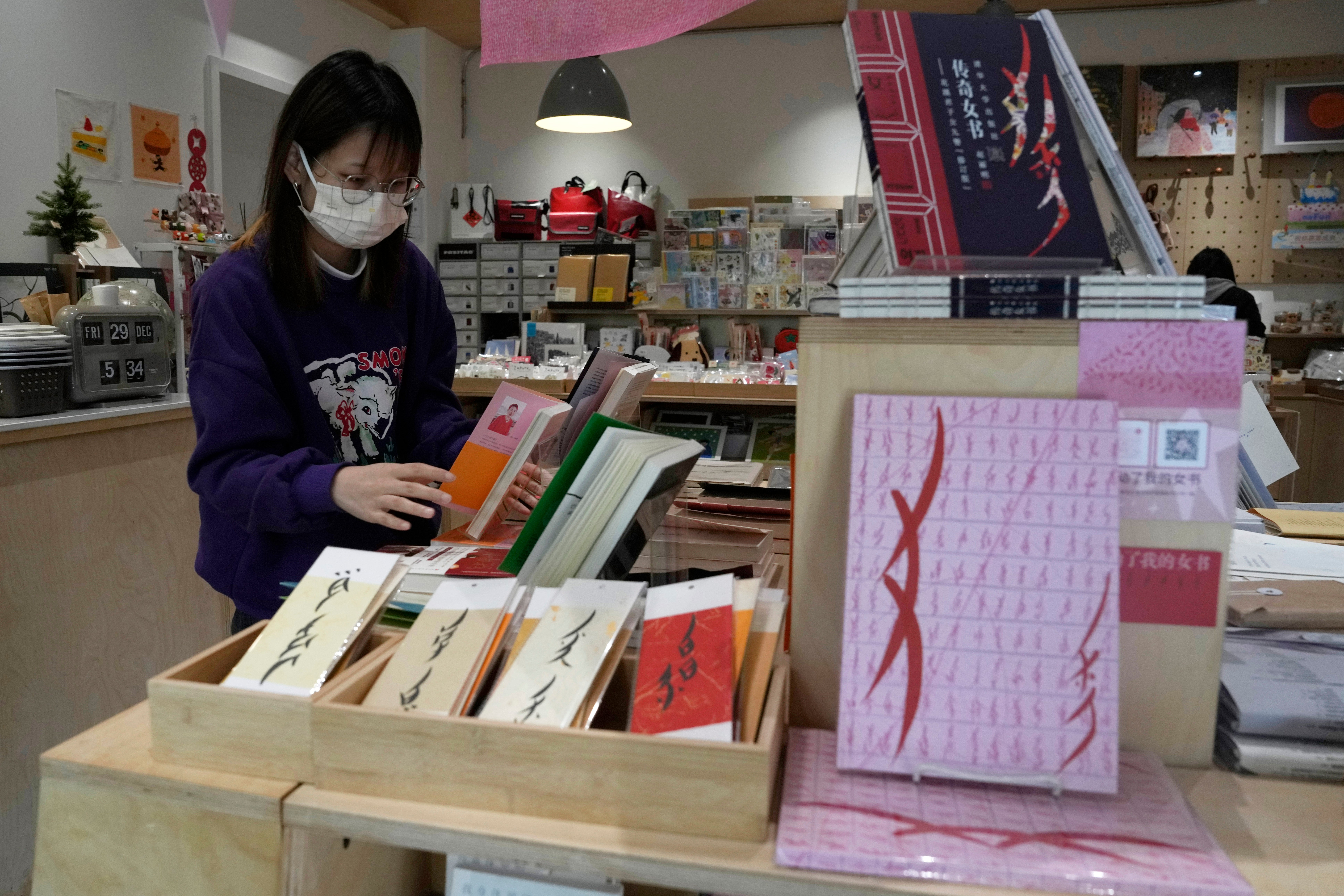 A worker arranges books at a bookstore specializing in nüshu