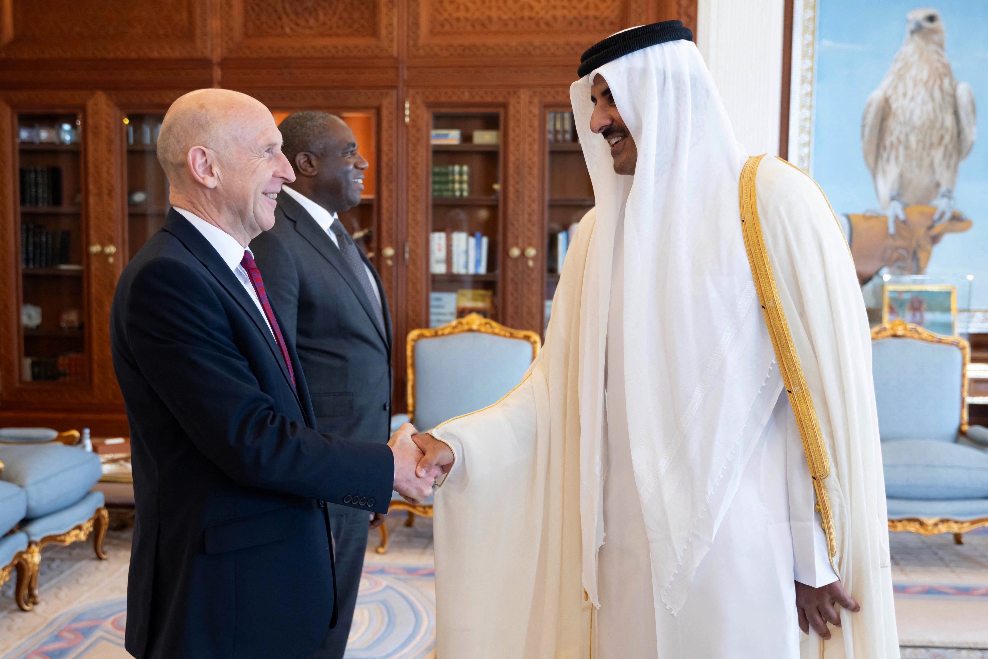 Qatar's Amir Sheikh Tamim bin Hamad al-Thani (R) shaking hands with Britain's Minister of Defence John Healey as Britain's Minister of Foreign Affairs David Lammy (C) stands by, at the office at the Amiri Diwan in Doha on July 31, 2024