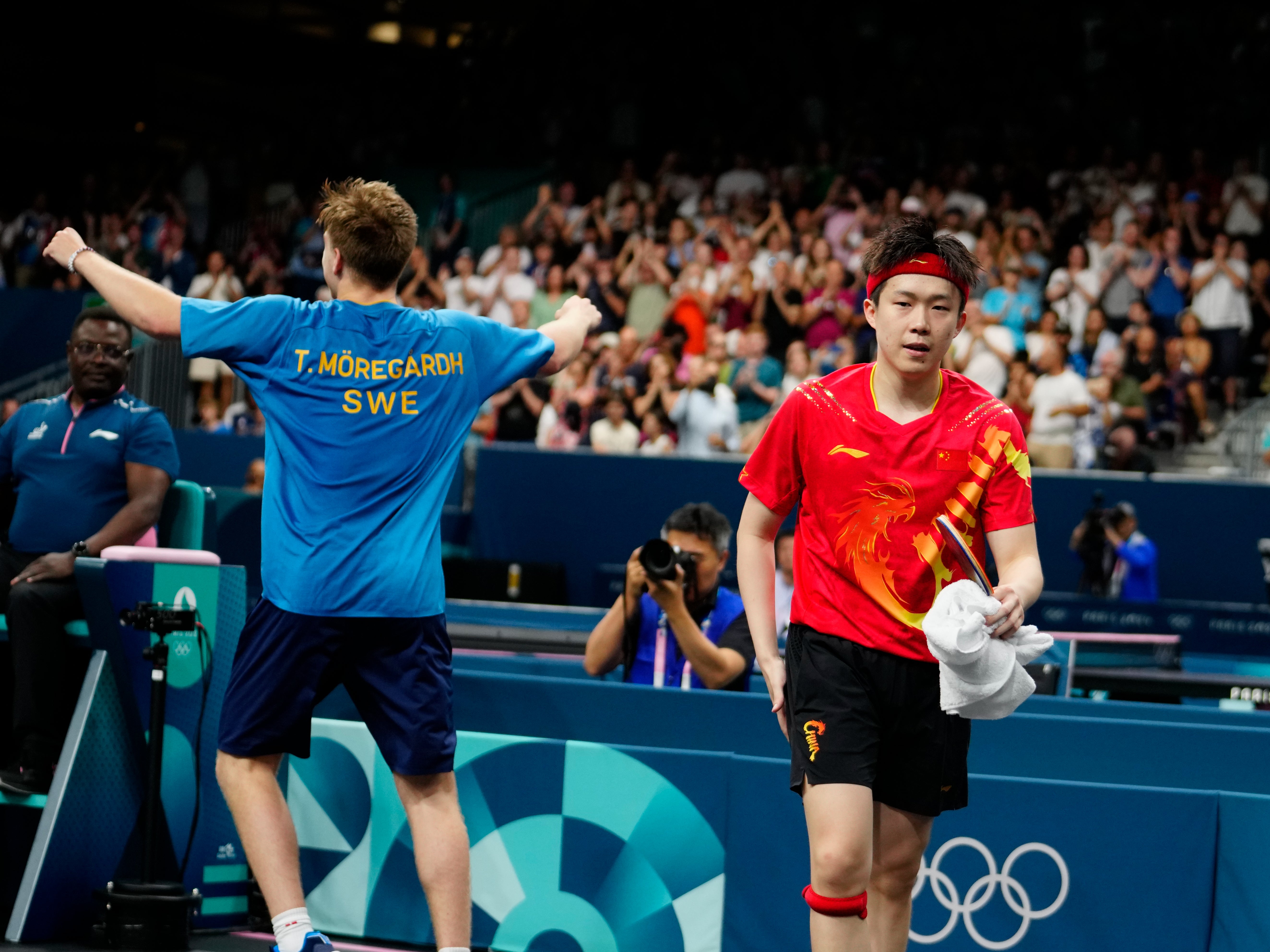 Sweden's Truls Moregrad, left, reacts after his win against China's Wang Chuqin