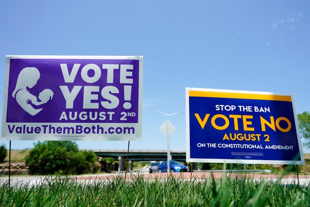 <p>Two opposing signs ask residents to vote “yes” and “no” to remove the right to an abortion from the Kansas constitution. A Kansas woman is suing a local hospital because she claims they refused to provide her an abortion on the day of the vote due to concerns about the ‘heated’ political environment</p>