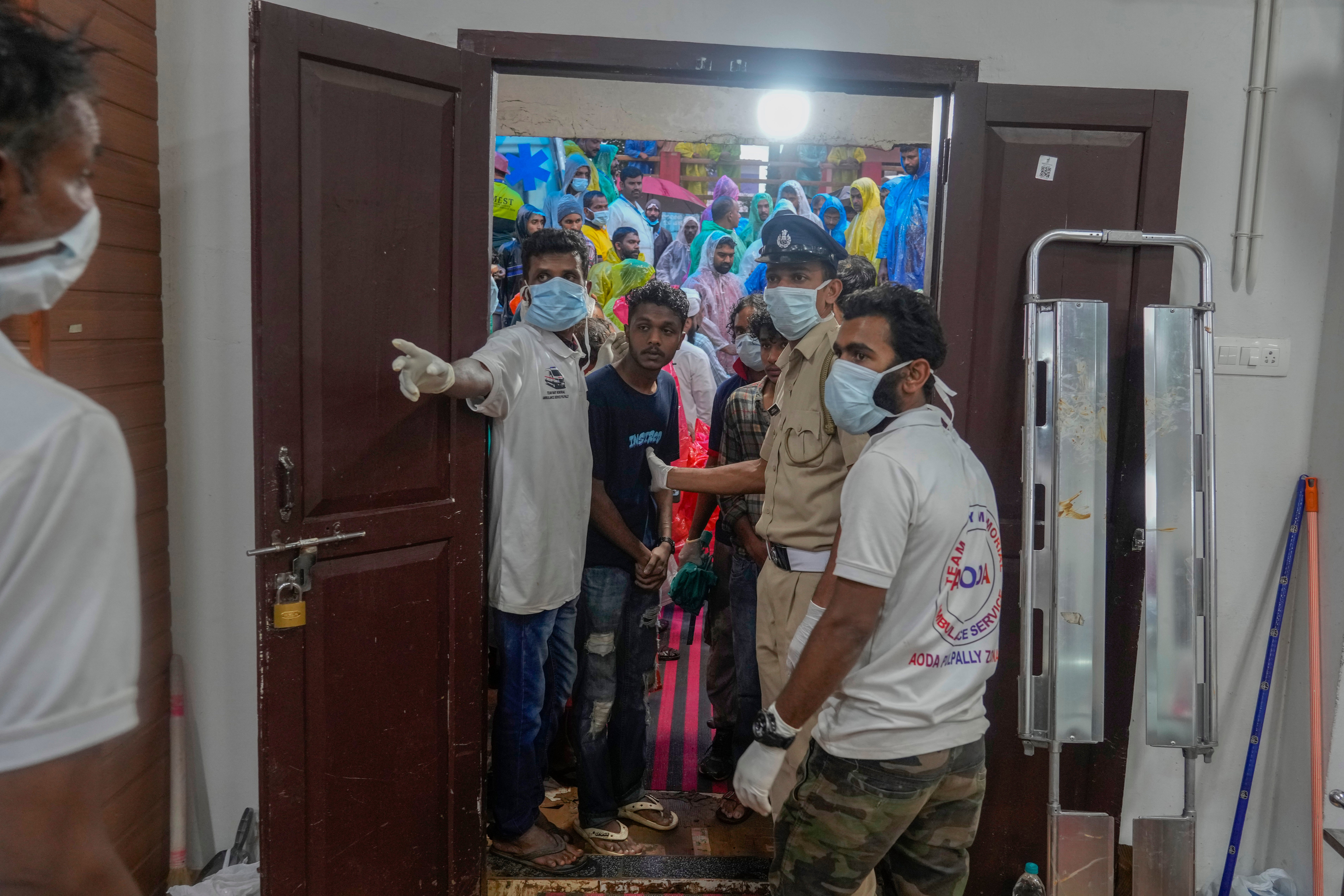 People wait to check the identity of the victims at a morgue following Tuesday's landslides in Wayanad, Kerala state, India