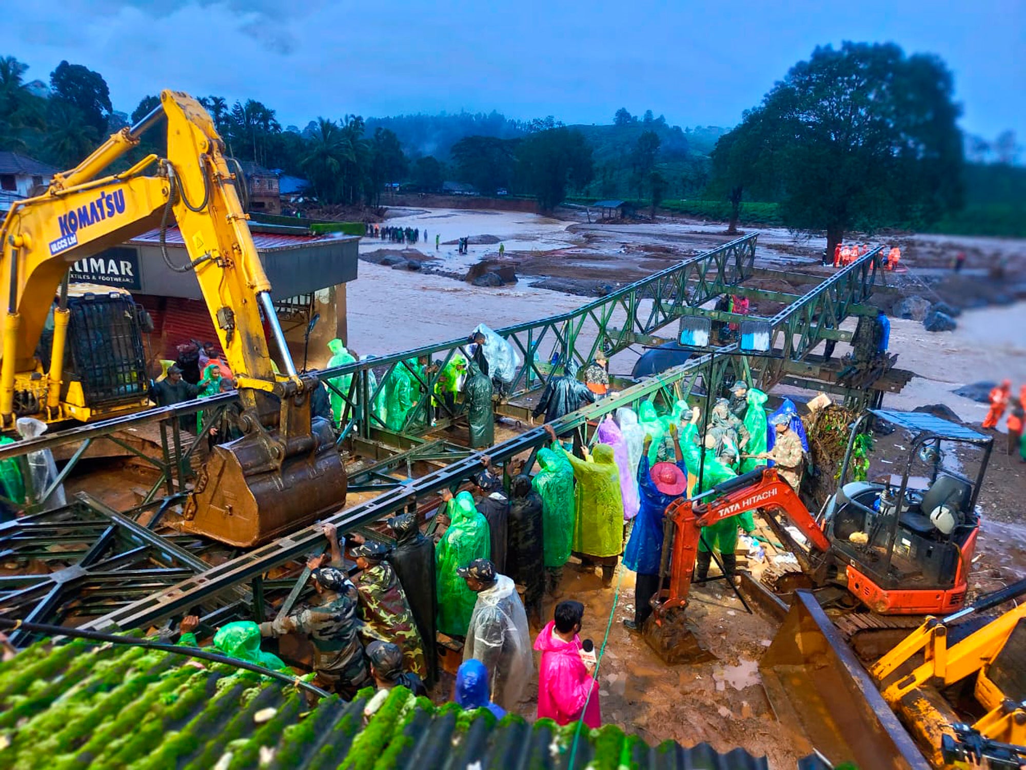 Indian Army soldiers assemble a prefabricated bridge over a river on the second day of rescue operations in a landslide-hit village in Wayanad, Kerala, southern India.