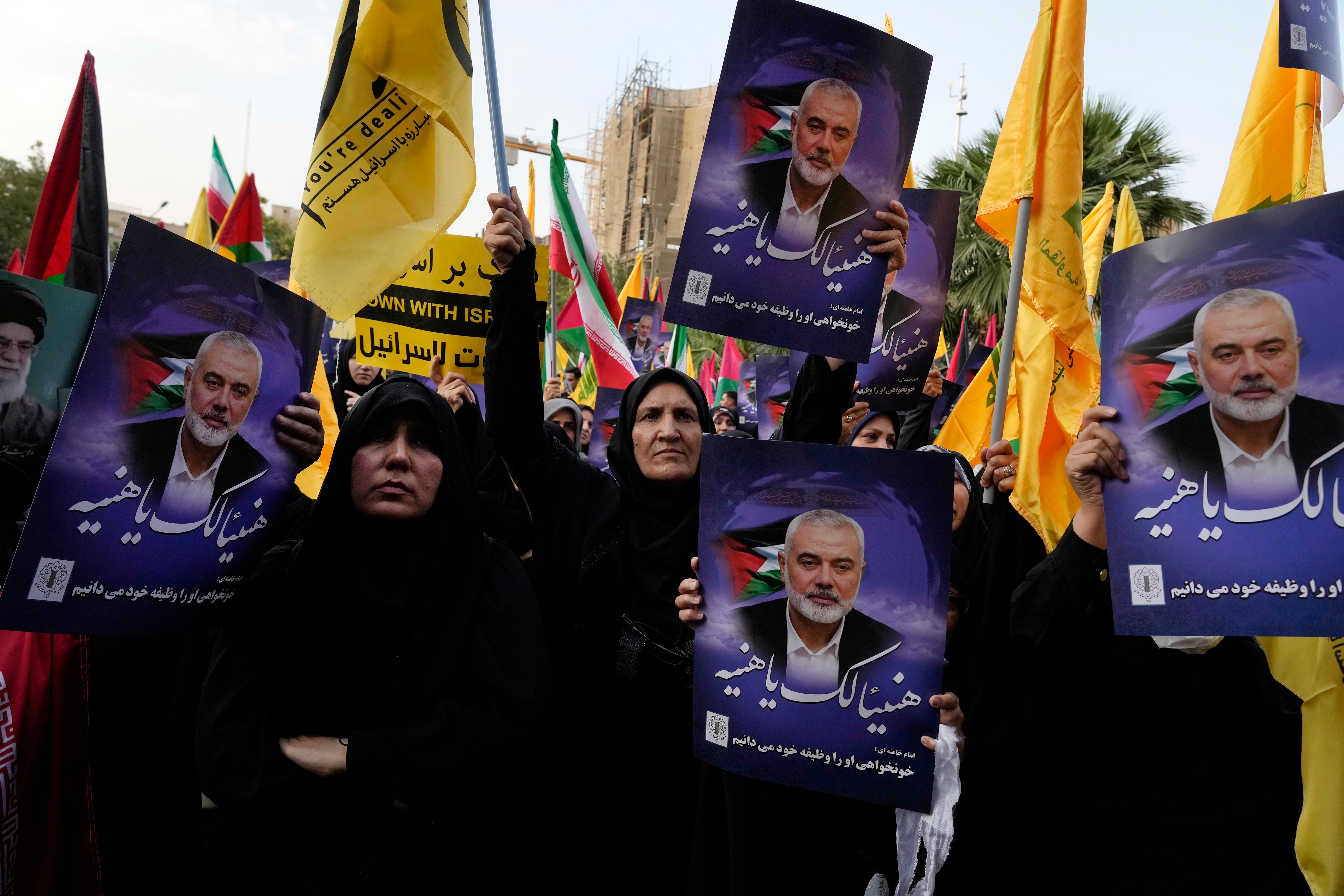 Iranian protesters wave Iranian, Palestinian and Lebanon’s militant Hezbollah group flags in a demonstration to condemn killing of Hamas leader Ismail Haniyeh