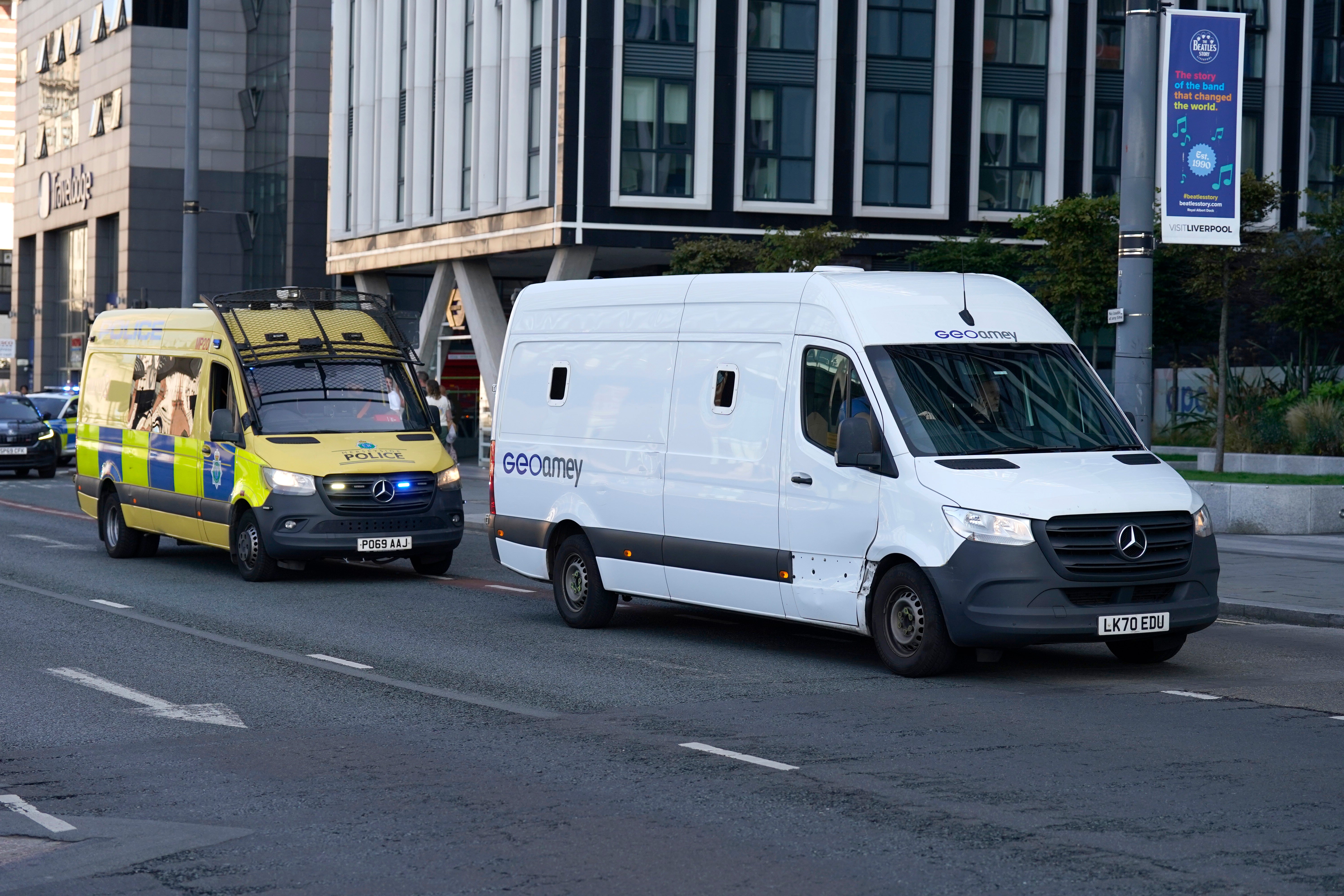 A prison van escorted by multiple police vehicles arrives at Liverpool Magistrates' Court