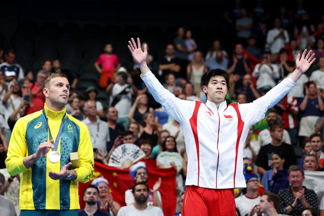 <p>Kyle Chalmers aplaude a Pan Zhanle en el podio olímpico</p>