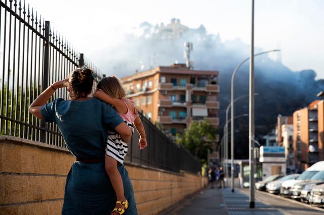 <p>Residents watch a large fire that broke out in the Monte Mario area in Rome, Italy, 31 July 2024</p>