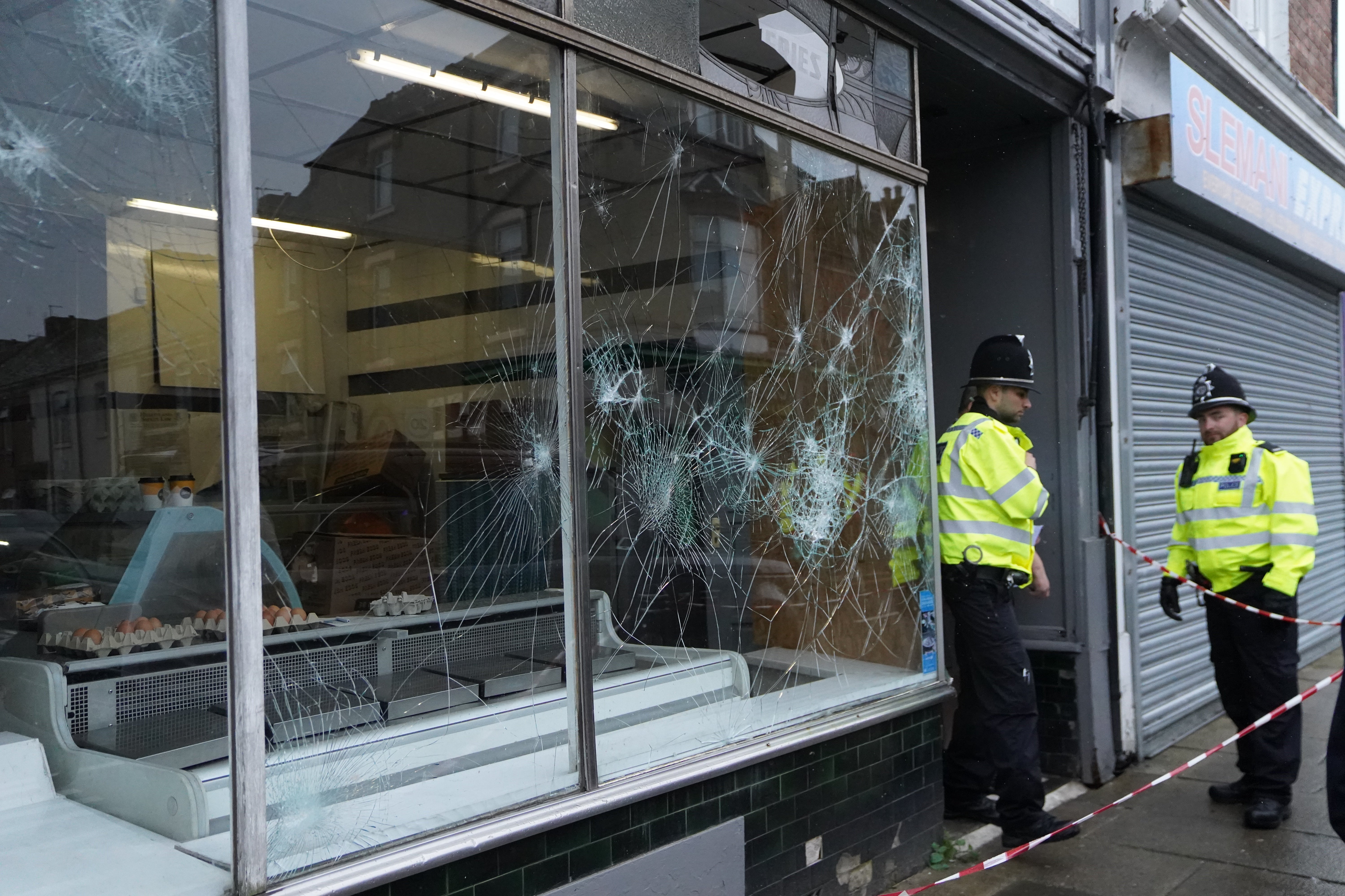 Demonstrators set fire to a police car and pelted officers with missiles, including glass bottles