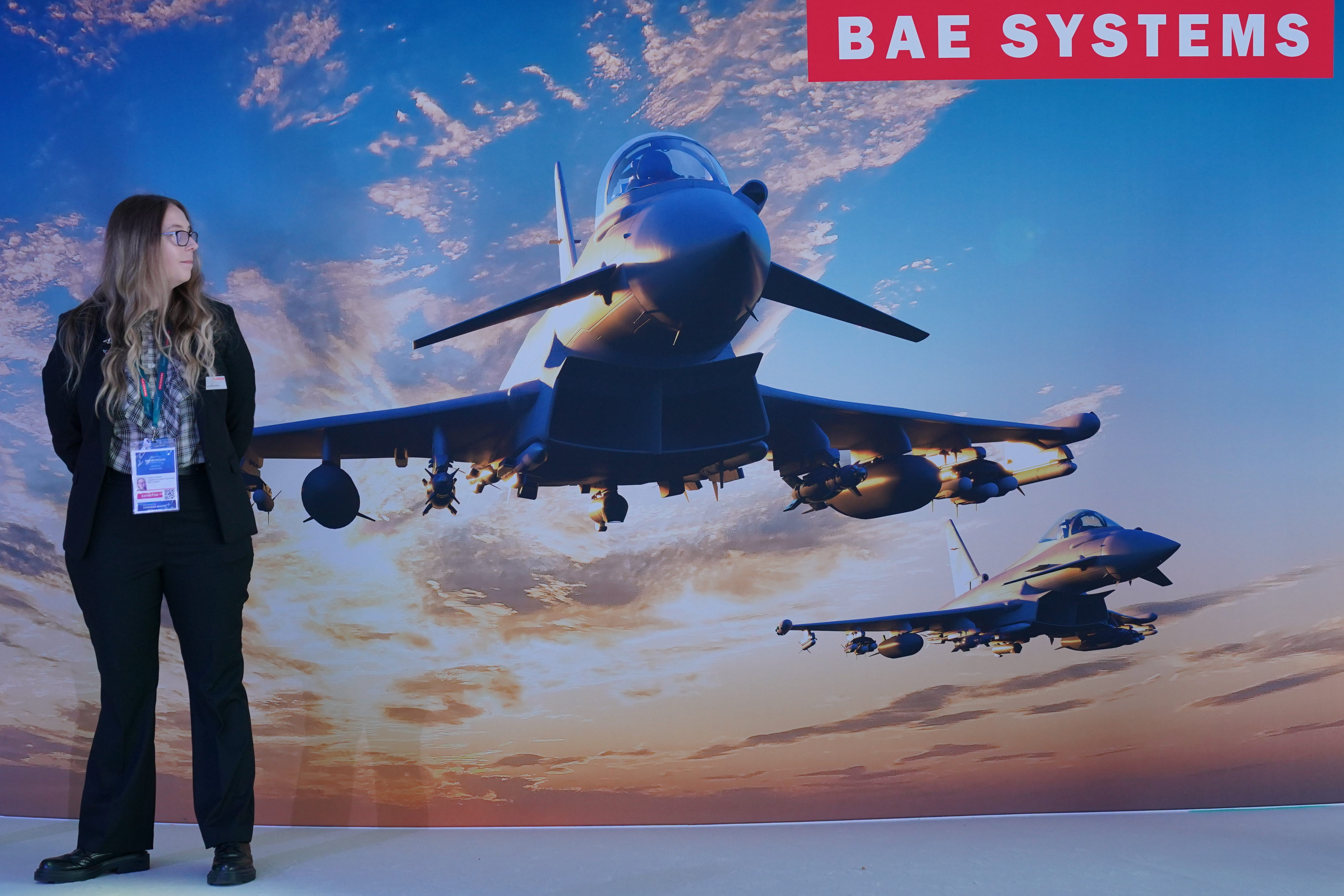 A woman stands next to a sign for BAE Systems at the Farnborough International Airshow (Jonathan Brady/PA)