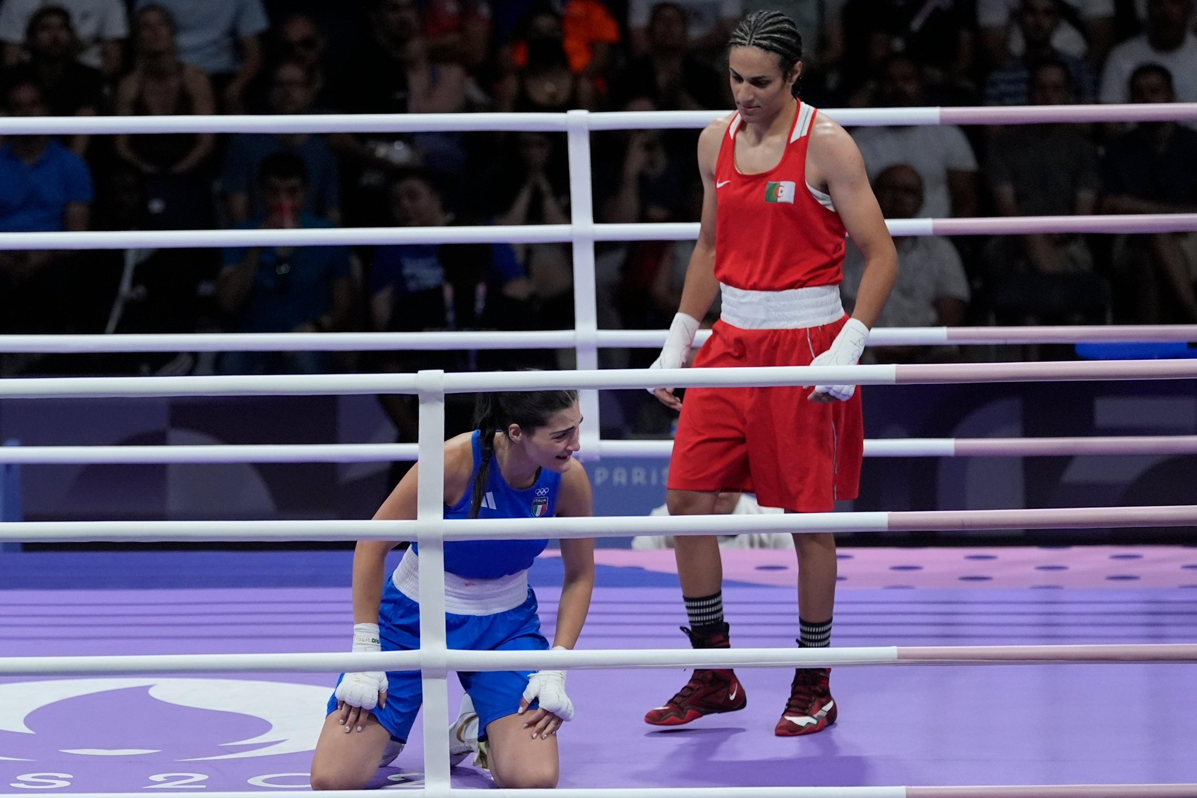 Imane Khelif, right, stands over Angela Carini