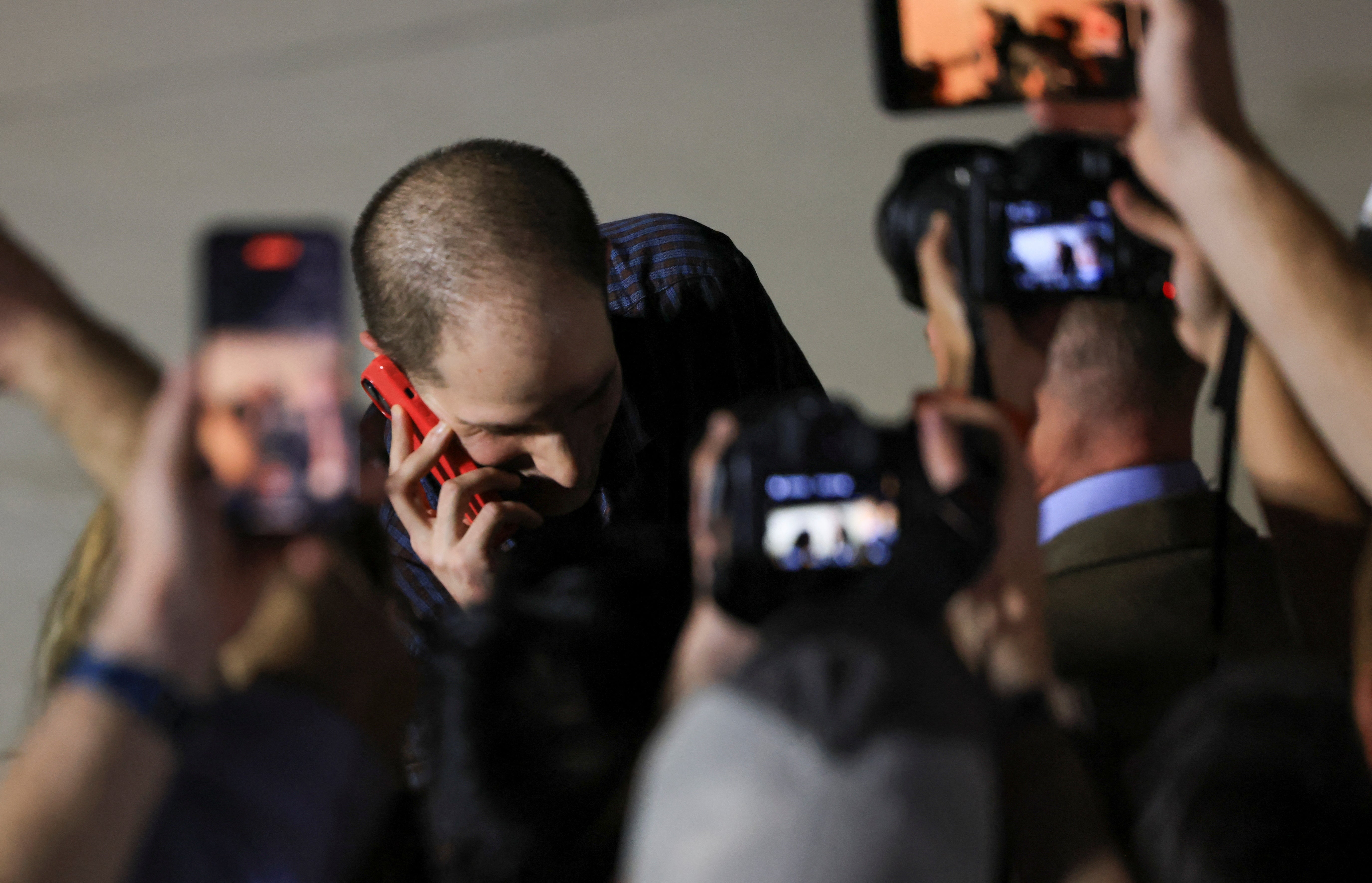 Evan Gershkovich, who was released from detention in Russia, speaks on a mobile phone after disembarking from a plane