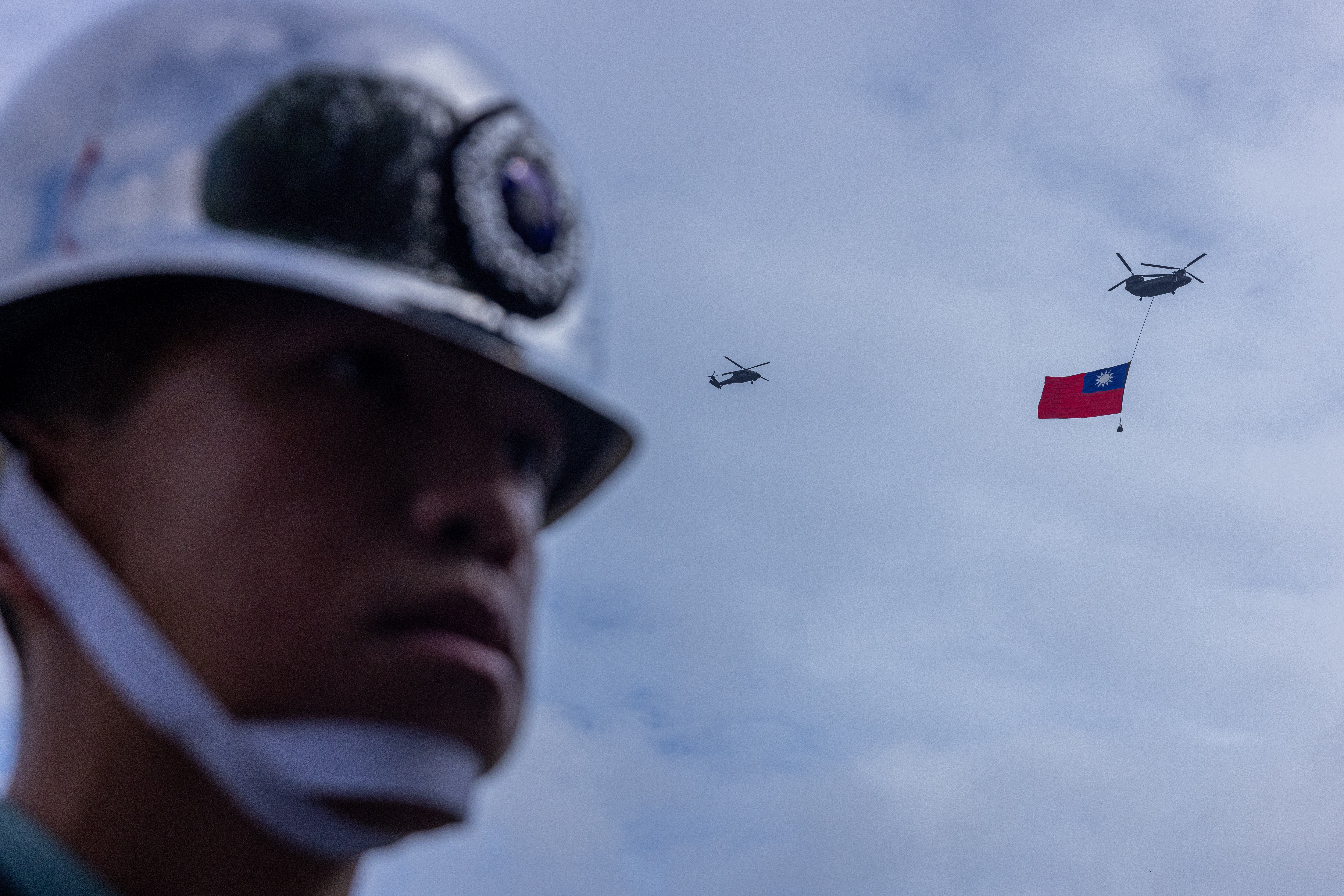 A helicopter hoists Taiwan’s national flag during Taiwan National Day