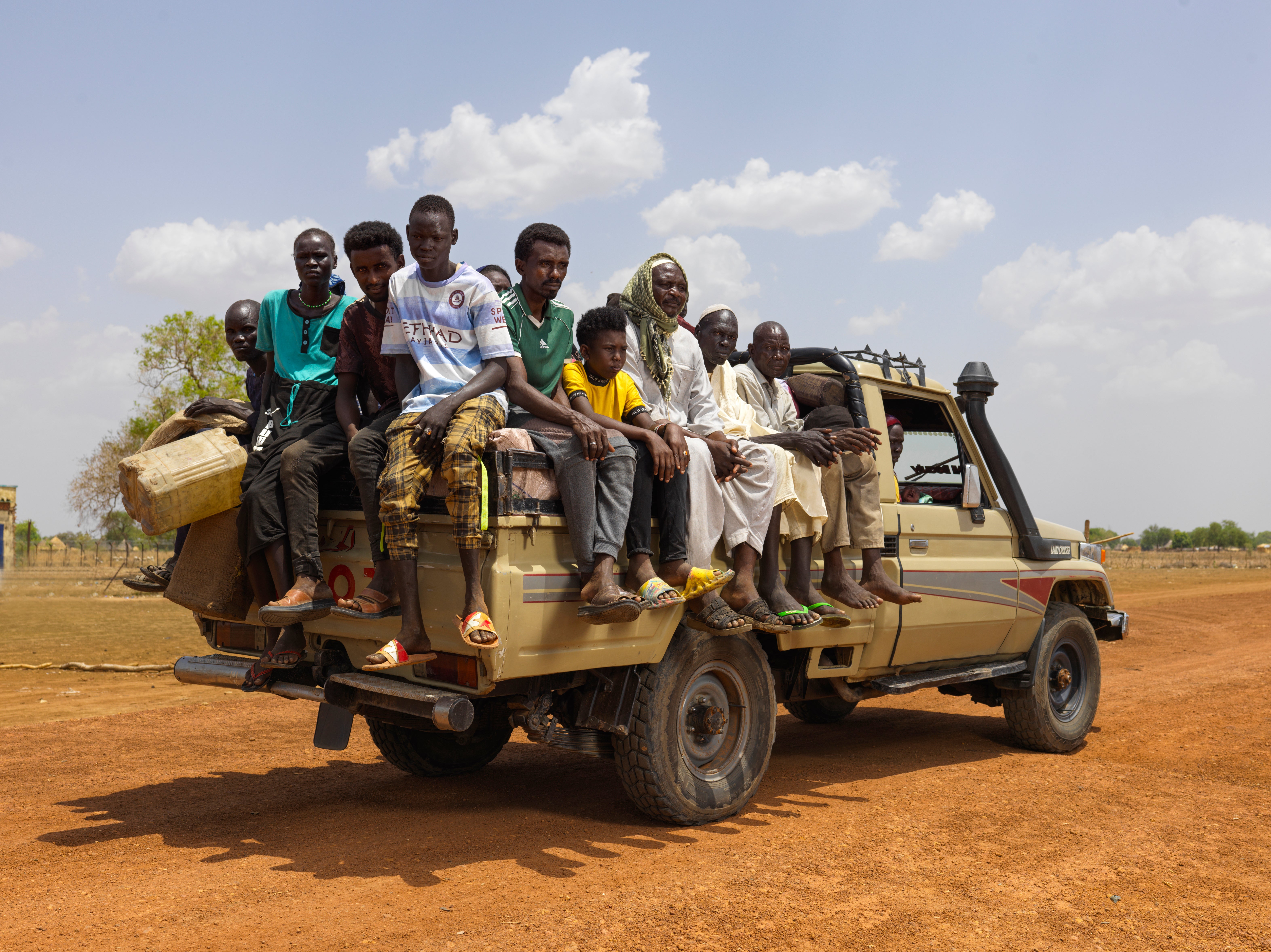 Families arrive in Majok Yinthiou, South Sudan, in the back of a pickup truck