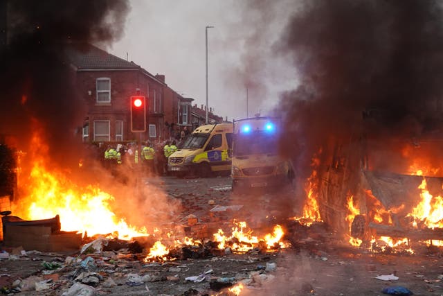 <p>Riot police hold back protesters near a burning police vehicle after disorder broke out on July 30, 2024 in Southport, England. Rumours about the identity of the 17-year-old suspect in yesterday's deadly stabbing attack here have sparked a violent protest. </p>