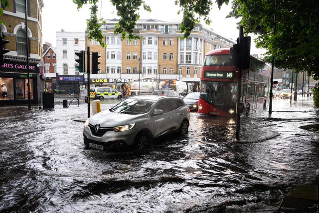 <p>A car negotiates a flooded section of road, as torrential rain and thunderstorms hit the UK. Earth’s string of 13 straight months with a new average heat record came to an end this past July</p>