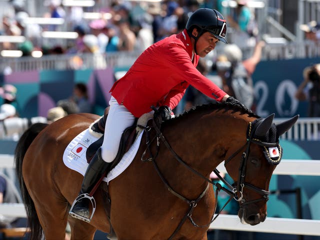 <p>Yoshiaki Oiwa interacts with horse MGH Grafton Street of Team Japan at the 2024 Paris Olympics</p>