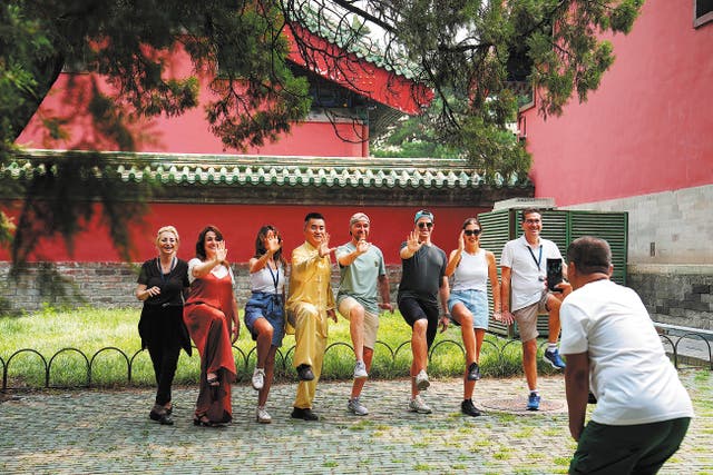 <p>Tourists pose for a group photo after practising tai chi at Beijing’s Temple of Heaven Park in July</p>