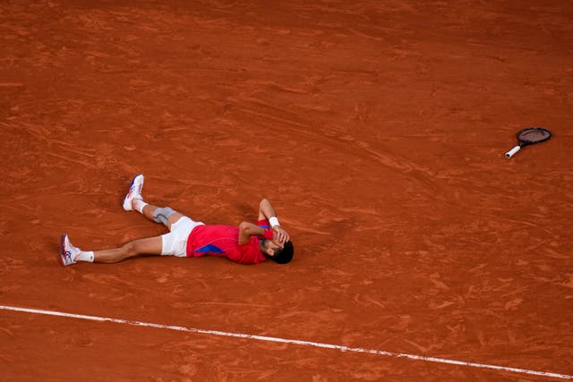 Novak Djokovic lies on the ground after beating Lorenzo Musetti (Manu Fernandez/AP)